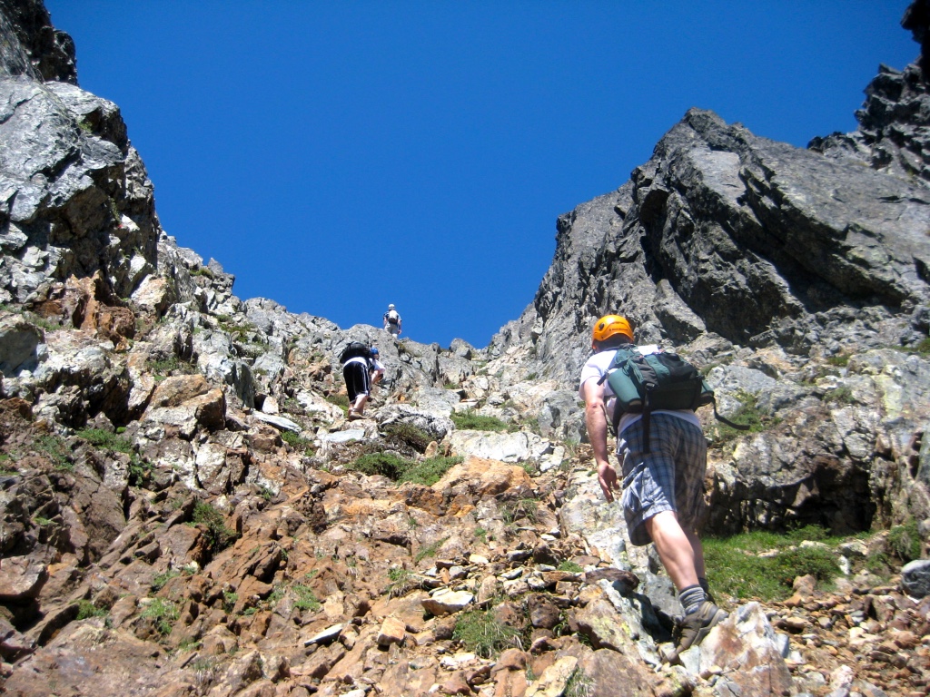 Mountain climbers scramble up a steep rocky slope on Kaleetan Peak
