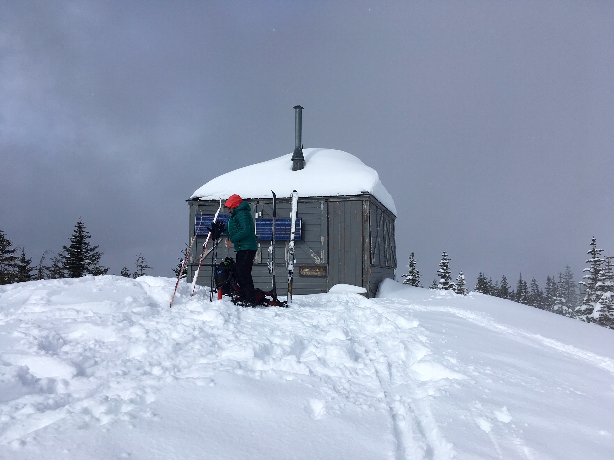 A gray wooden lookout cabin sits on summit of Sun Top mountain
