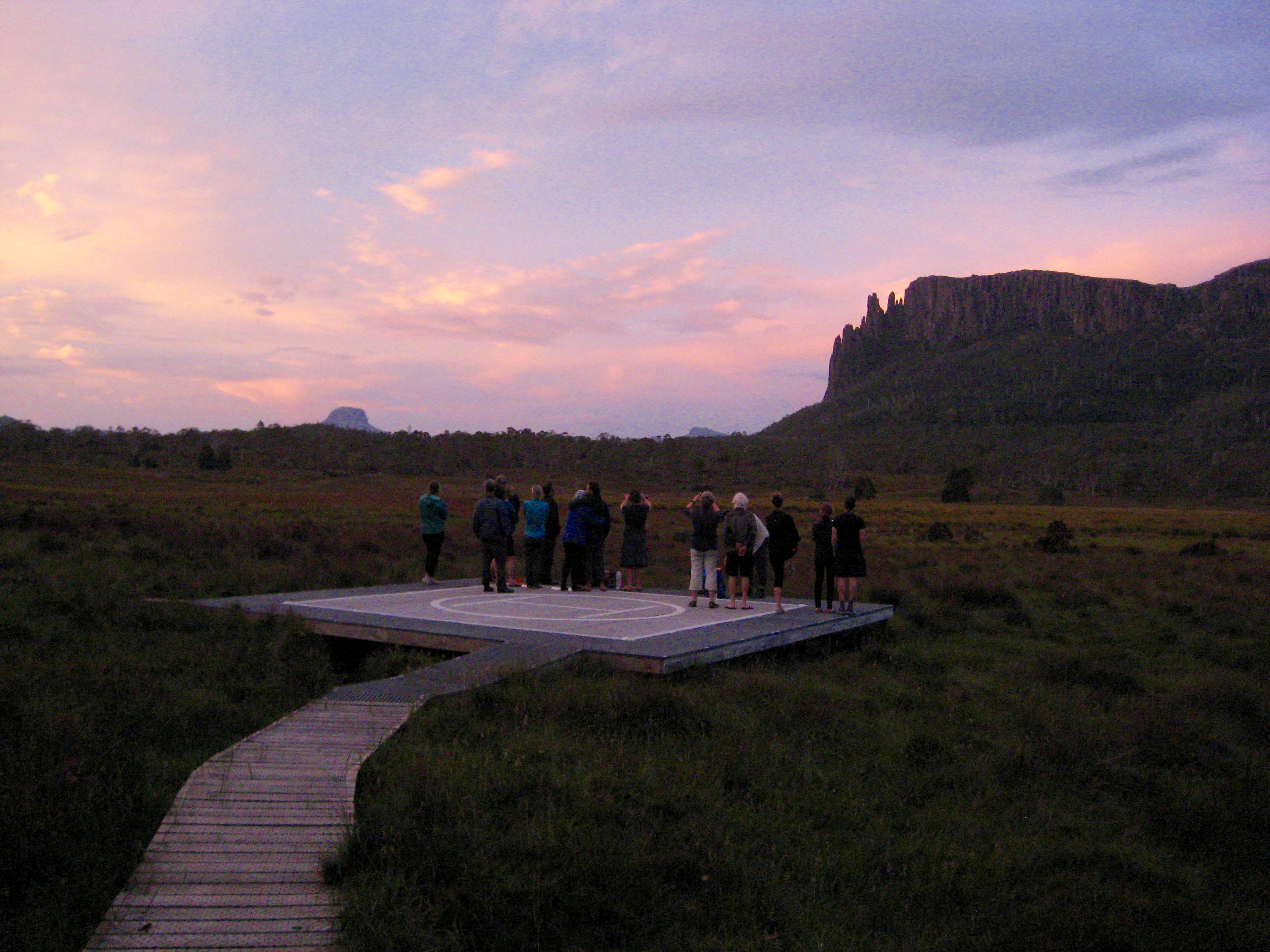Group of trekkers Watching Sunset From Helipad At Pelion Hut on the Overland Track