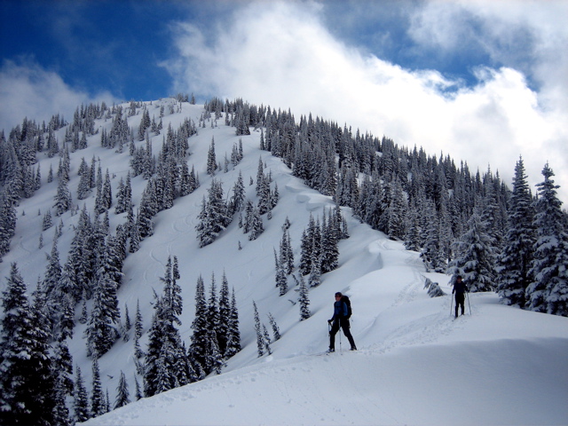 Backcountry skiers glide along a broad crest of Blue Bell Ridge