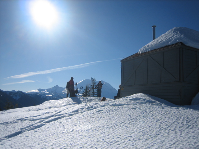 Afternoon sun shines on a snow-covered cabin at Sun Top Lookout