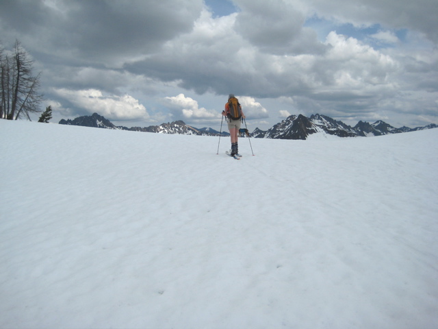 A lone skier glides over snowy Cutthroat Pass during a ski traverse