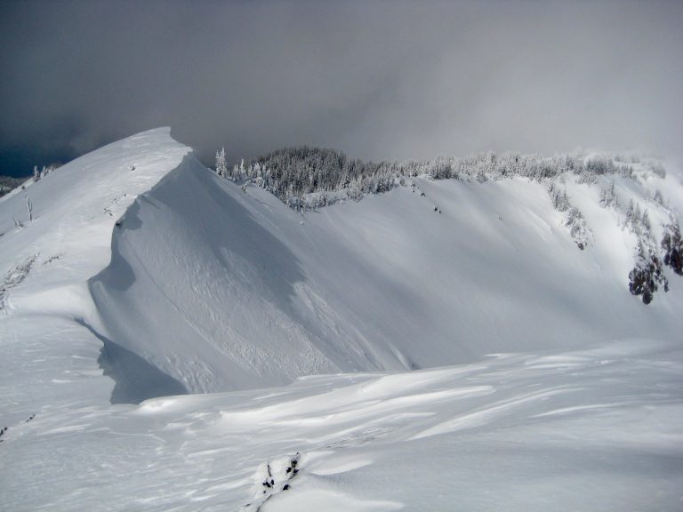 Looking down a corniced ridge from summit of Norse Peak in the Chinook Mountains