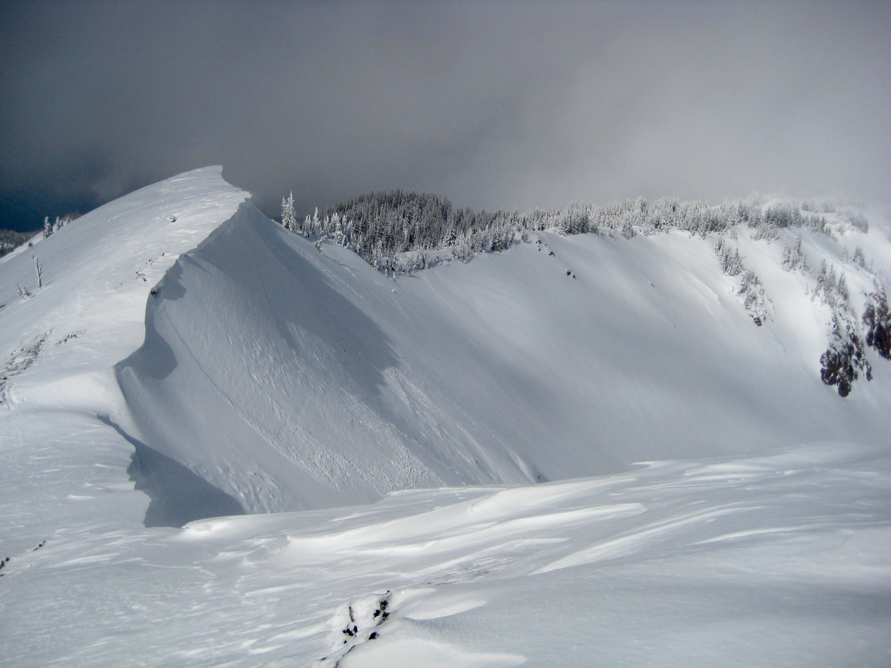 Looking down a corniced ridge from summit of Norse Peak in the Chinook Mountains