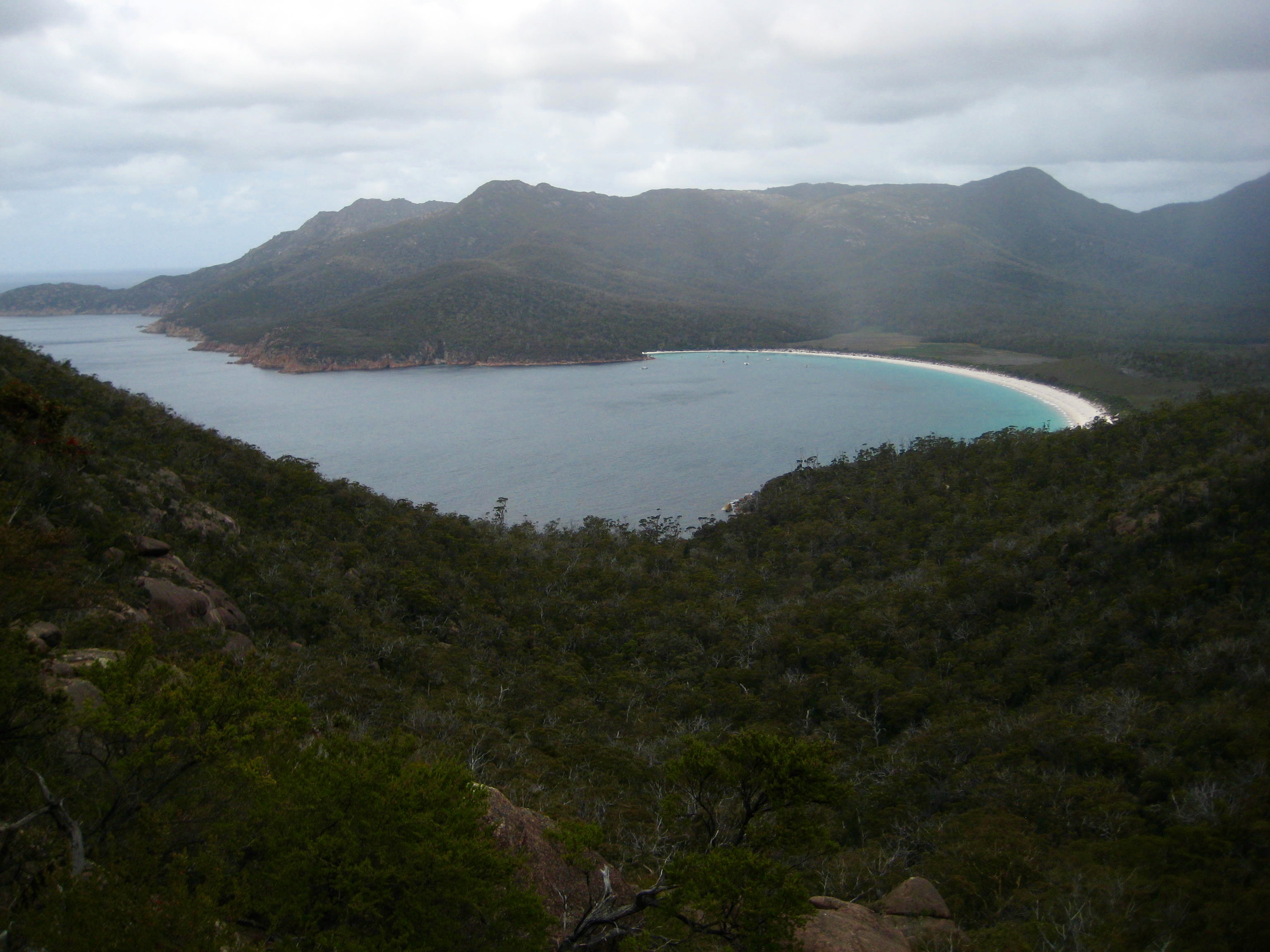 Wineglass Bay with high clouds as seen from the Amos-Mayson Saddle in Tasmania's Freycinet National Park