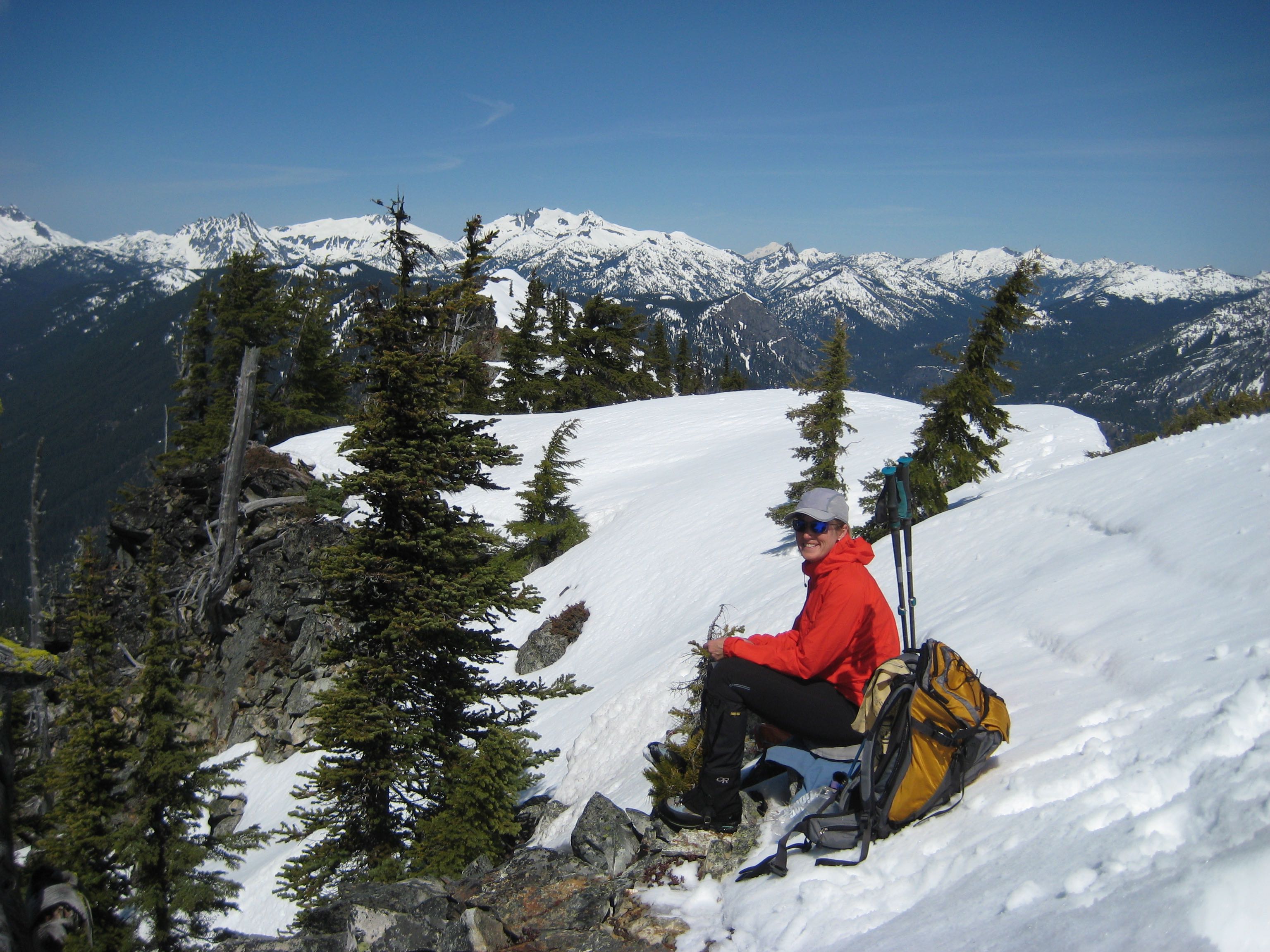 A snowshoer sits on the snow covered summit of Red Mountain in the Kachess Mountains