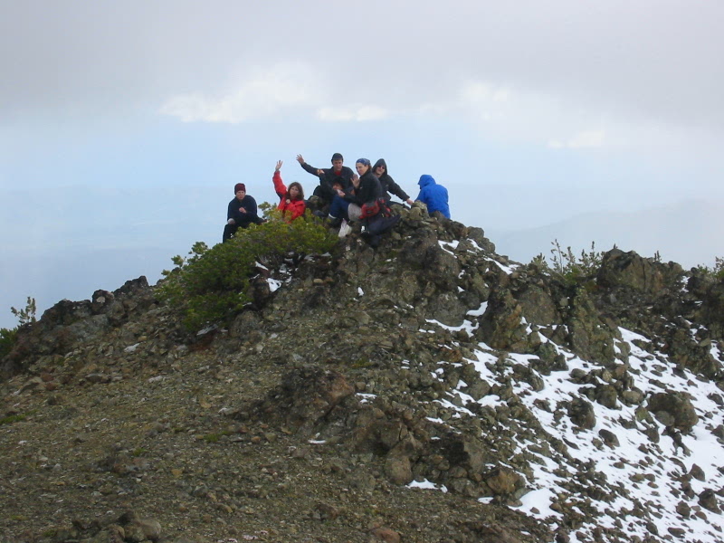 A group of climbers waves from summit of Three Brothers Mountain