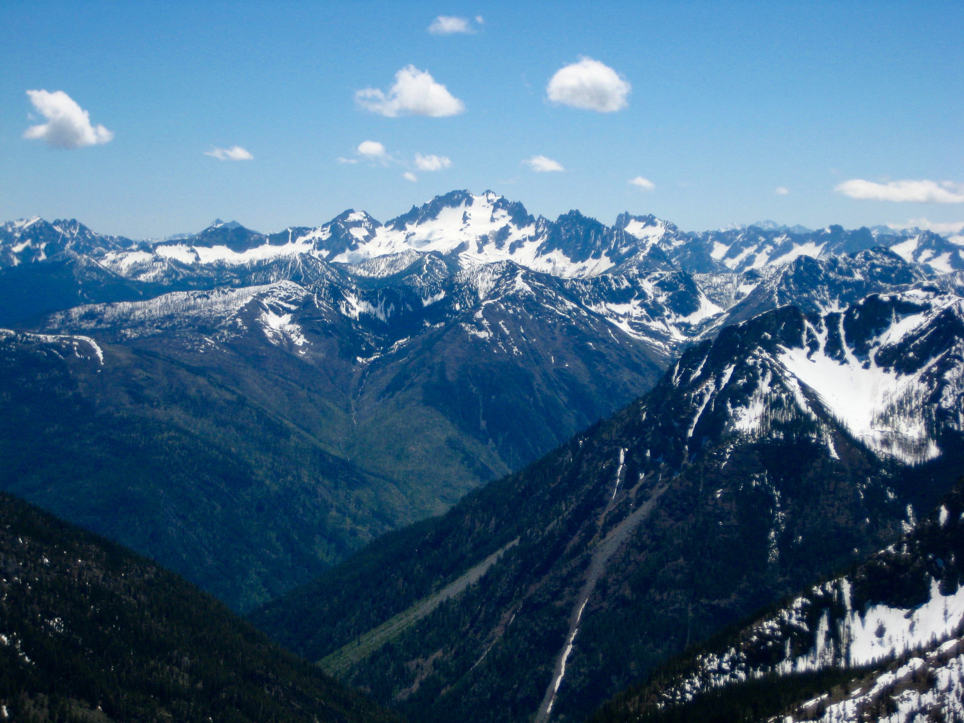Silver Star Mountain in the distance with blue skies and a few clouds as seen from the ridge of Beauty Peak in the Pasayten Wilderness