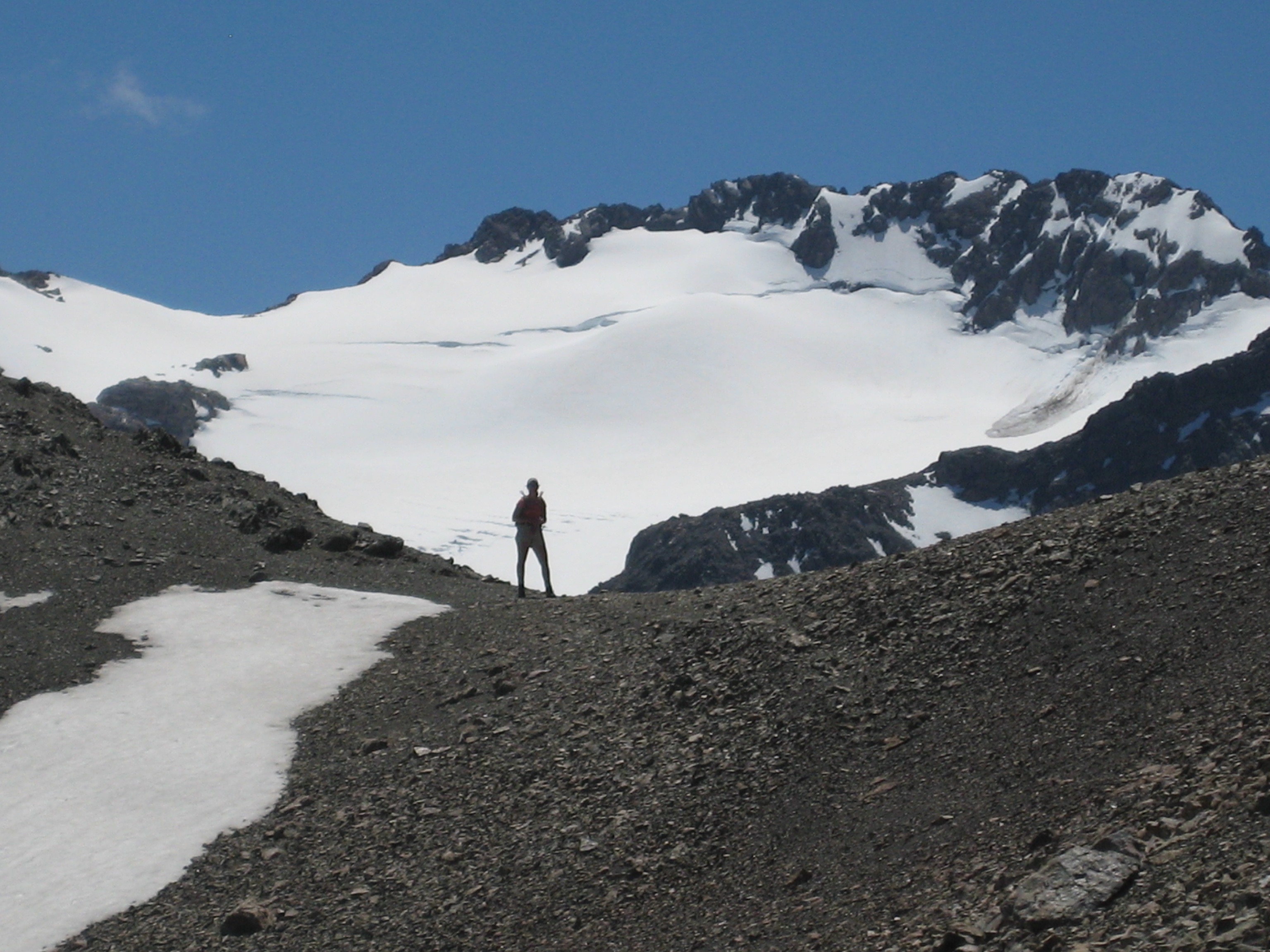 A hiker gazes at Mt Rolleston from a saddle below Avalanche Peak during the Avalanche--Crow Traverse