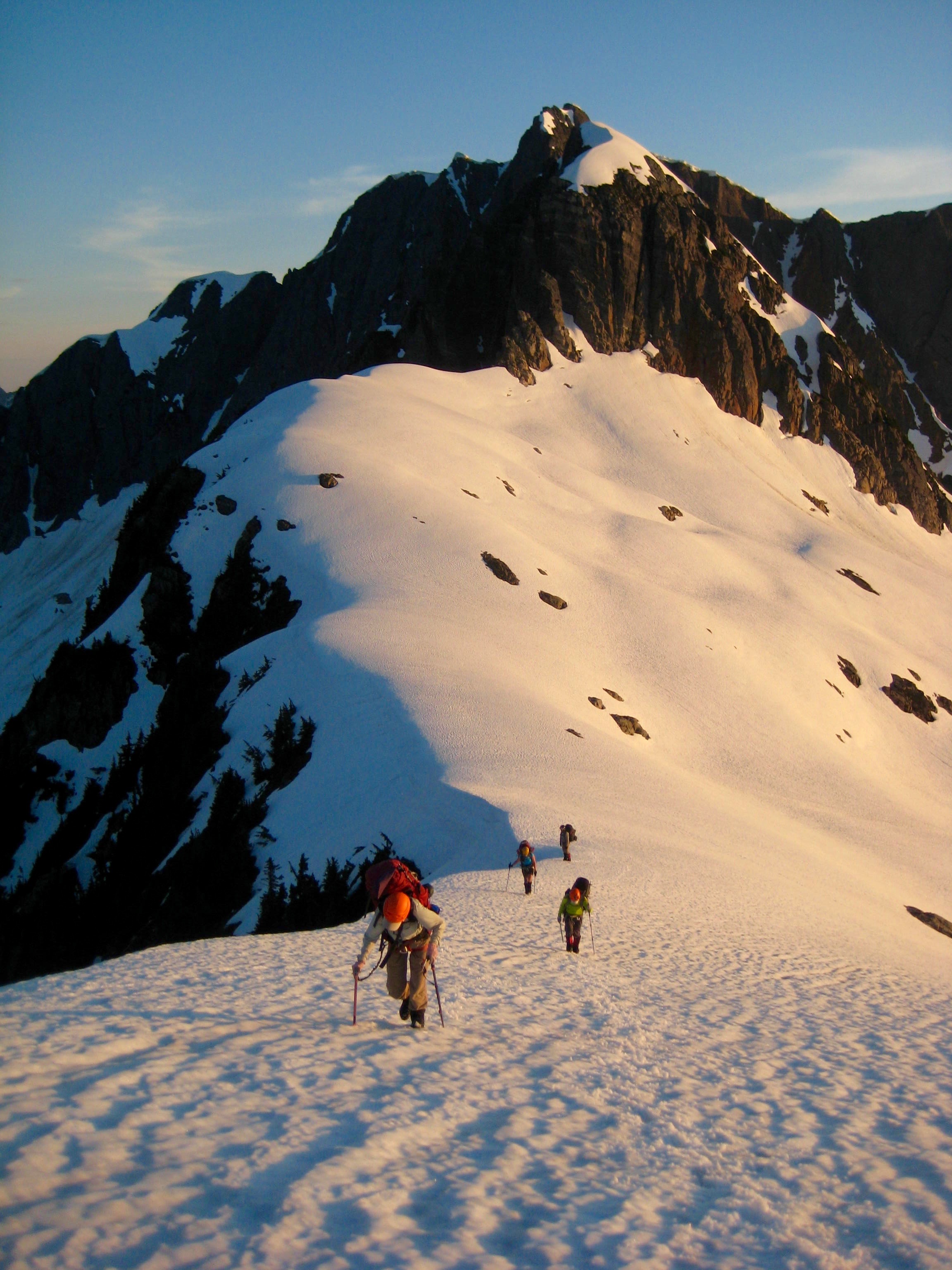 climbers booting up snow field to camp above Pickell Pass marking camp 2 on the Picket Traverse
