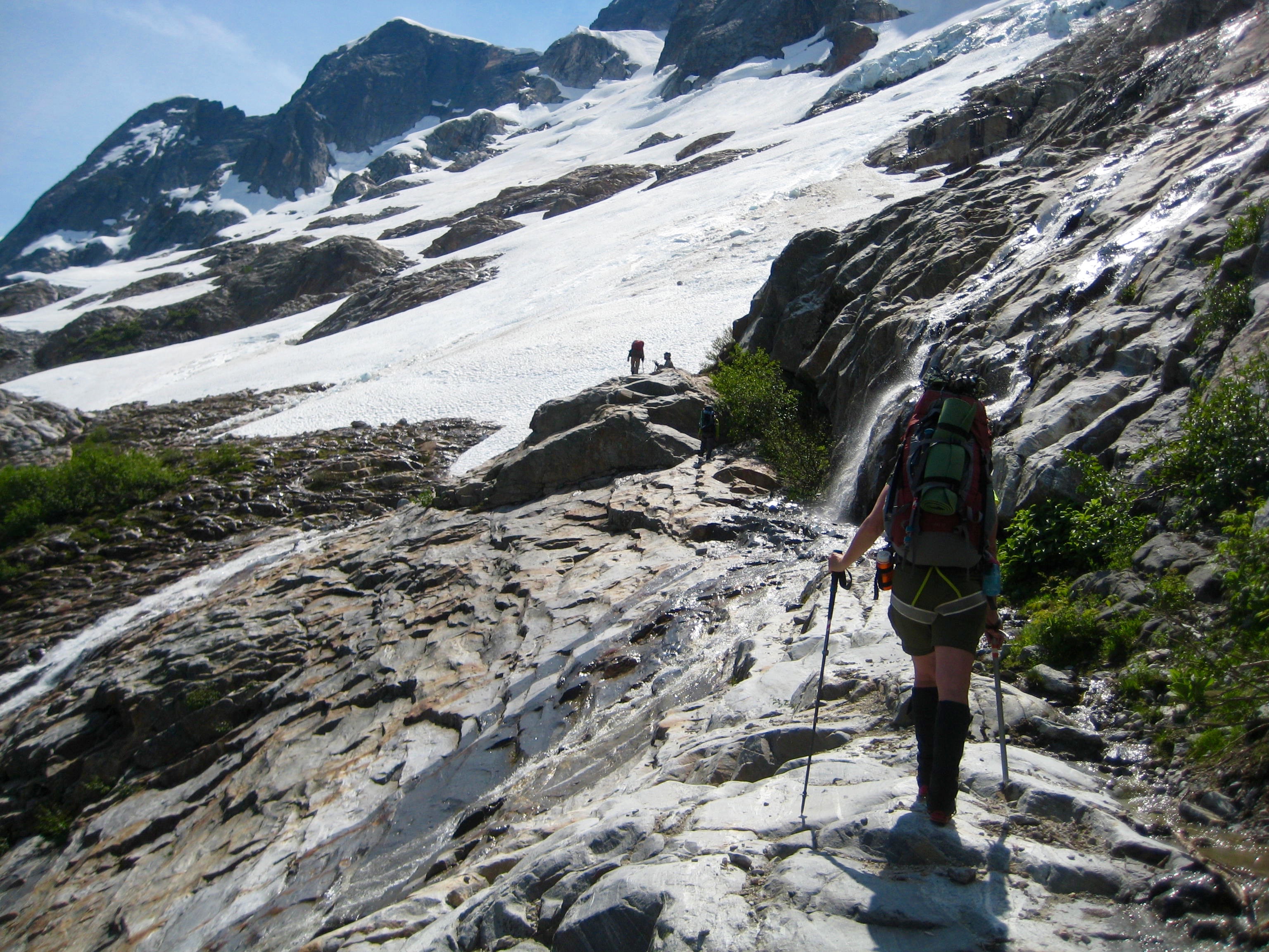 climber crossing the wet key ledge which leads to the McMillian Glacier
