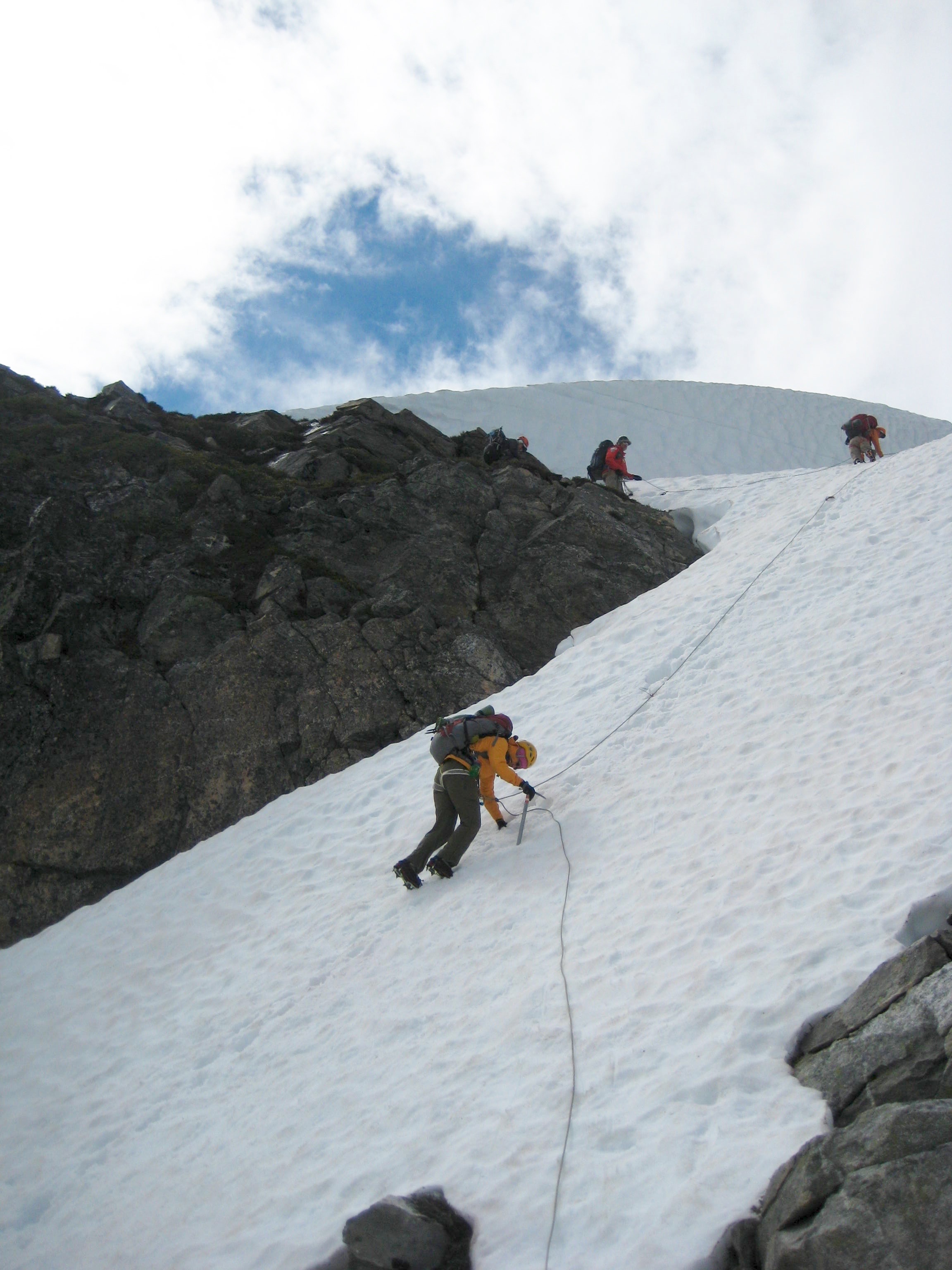 climbers descending steep snow using ropes and facing inward to get off Elephant Butte