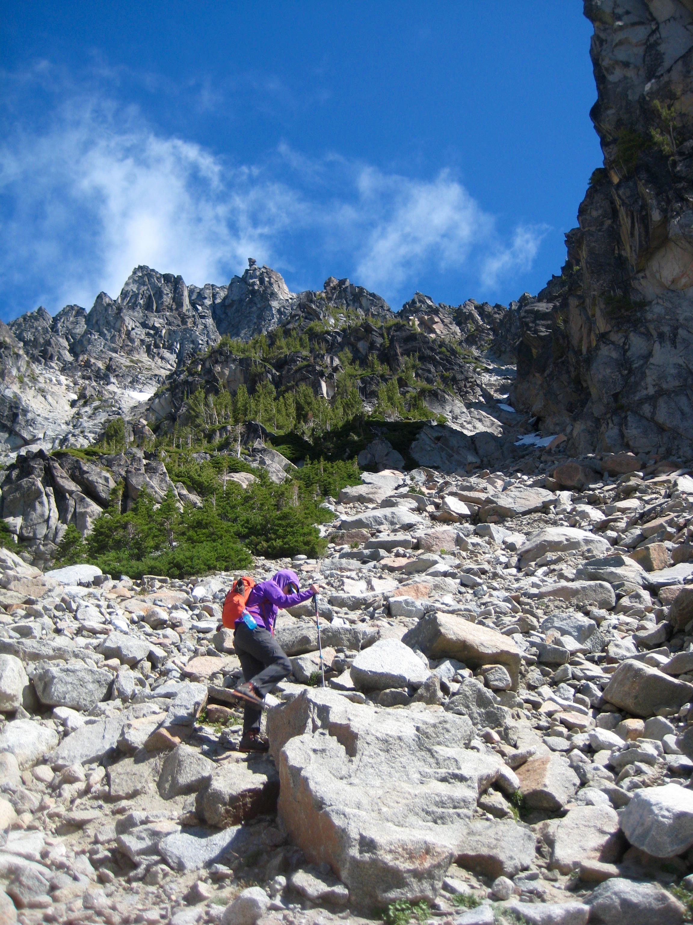 mountain climber ascending boulder gully on the southeast face of Sherpa Peak in the Icicle Mountains with balancing rock in the backgournd