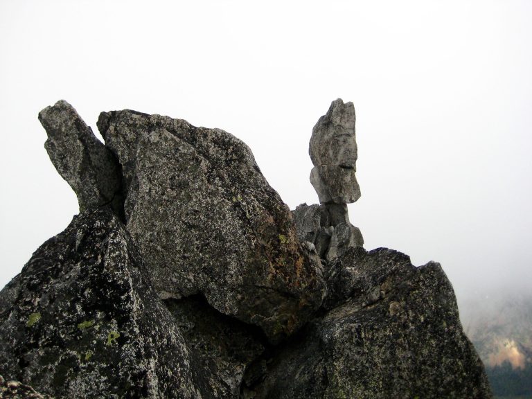 The summit of Sherpa Peak and the Sherpa Balanced Rock can be seen through a dense fog in the Alpine Lakes Wilderness