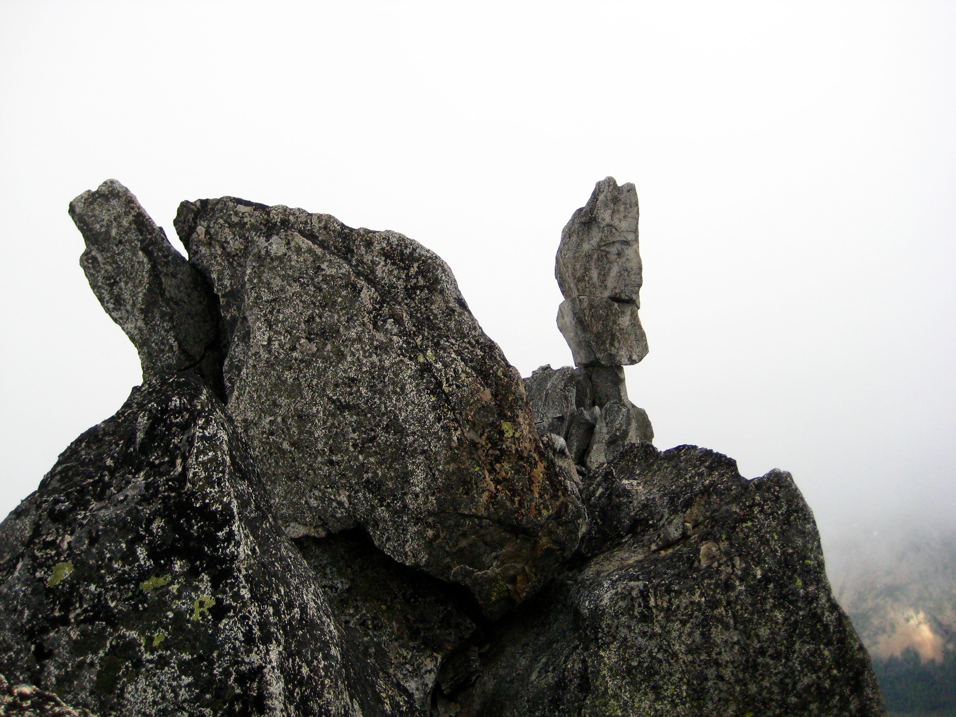 The summit of Sherpa Peak and the Sherpa Balanced Rock can be seen through a dense fog in the Alpine Lakes Wilderness