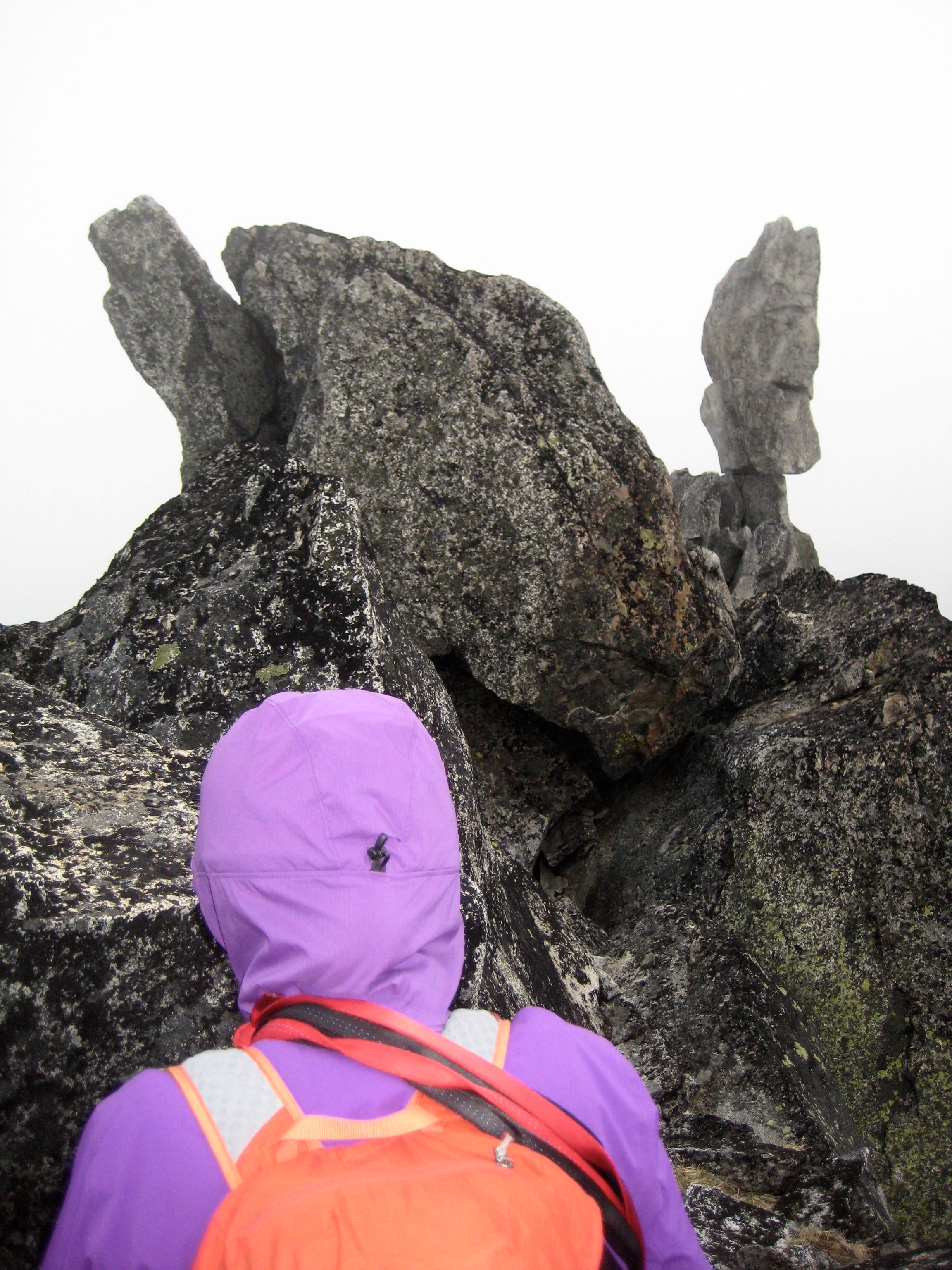 mountain climber looking at Balancing Rock on Sherpa Peak summit ridge in the Icicle Mountains