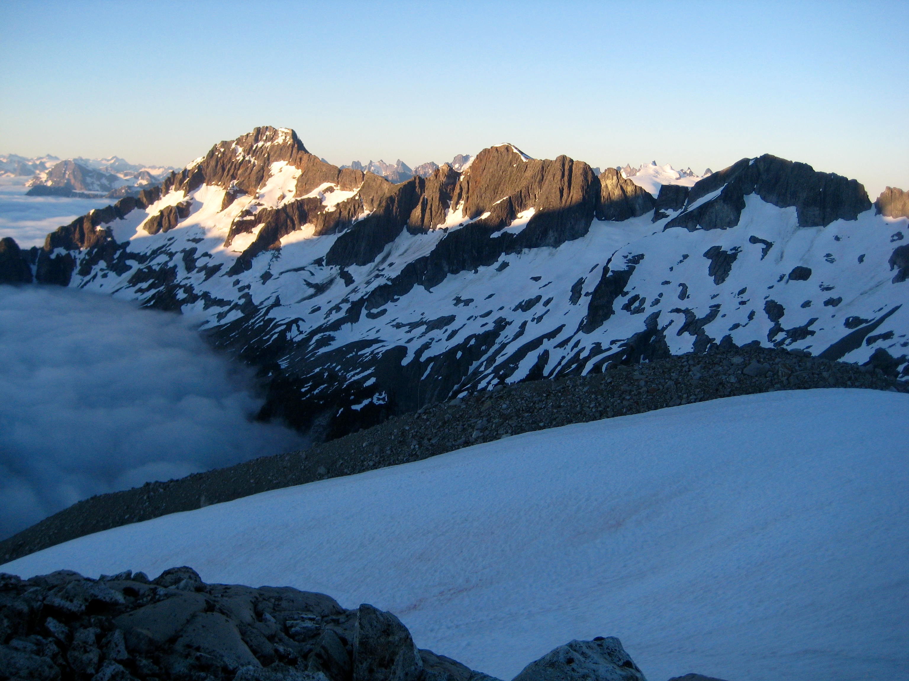 Near by mountain ridges with valley fog and snow patches from camp at Mt Redoubt saddle