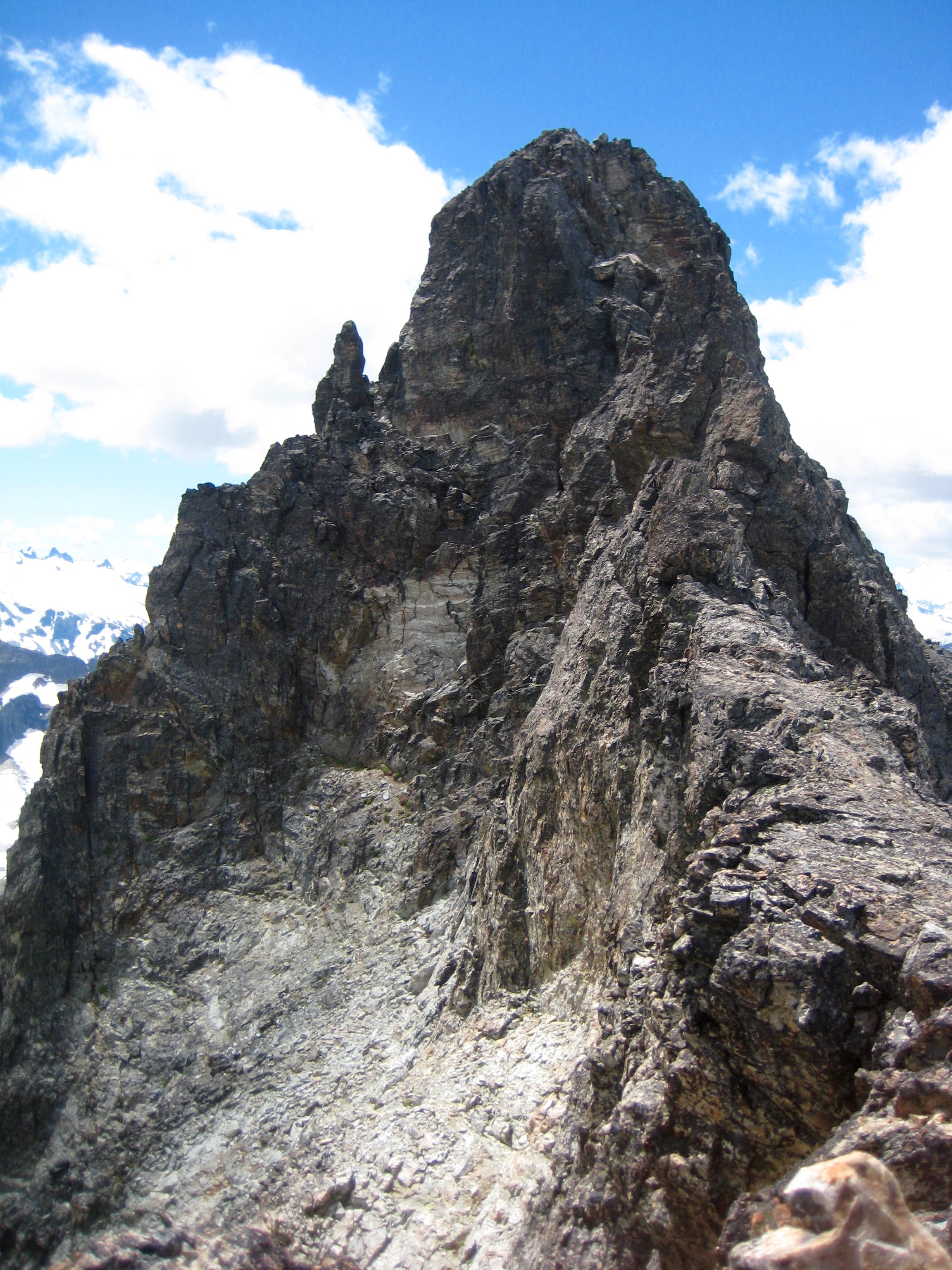 looking up the steep rocky summit tower of Easy Mox Peak in the American Chilliwack Mountains