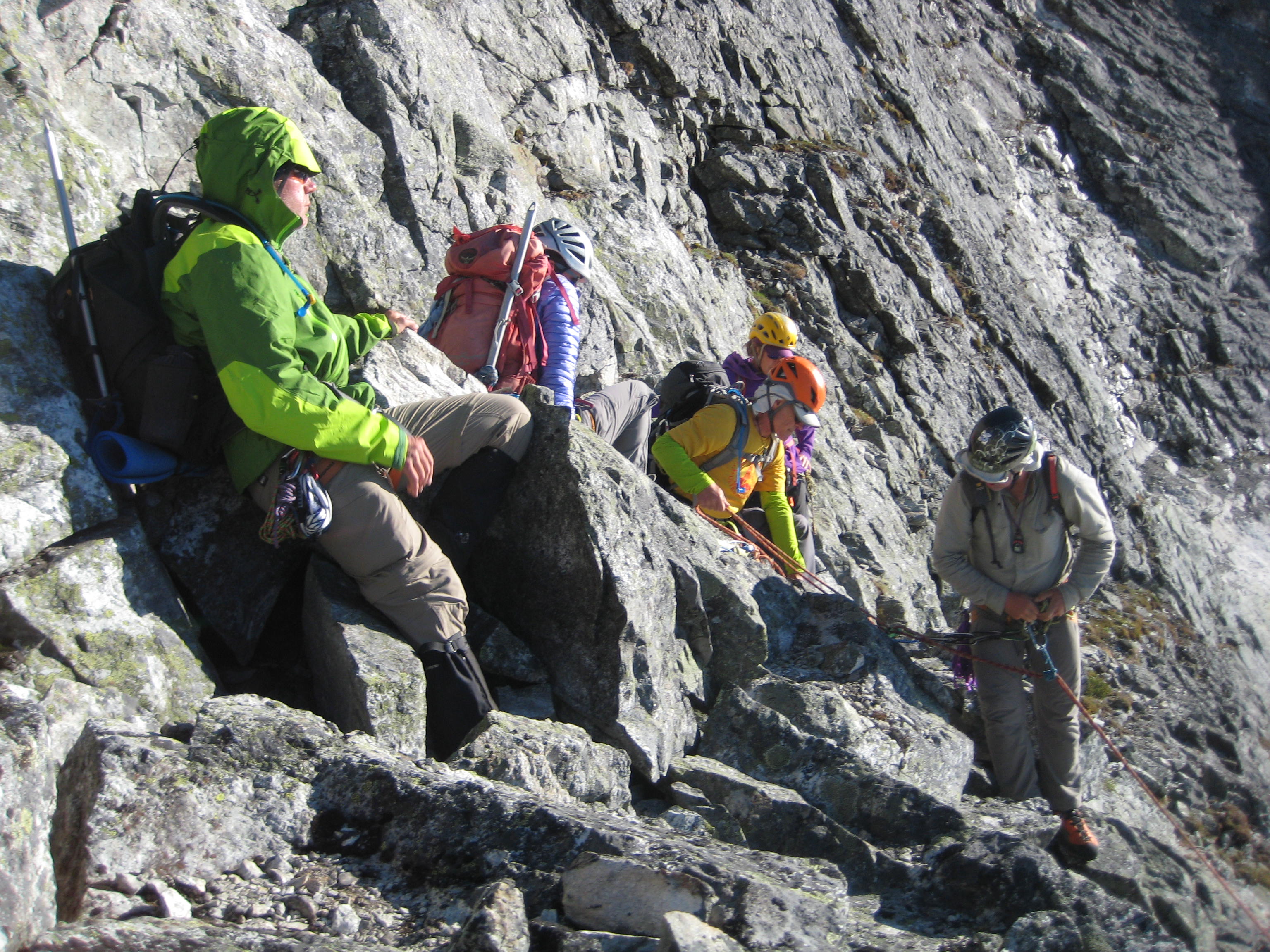 mountain climbers setting up a rappel on the steep rocky NE face of Easy Mox Peak in the American Chilliwack Mountains