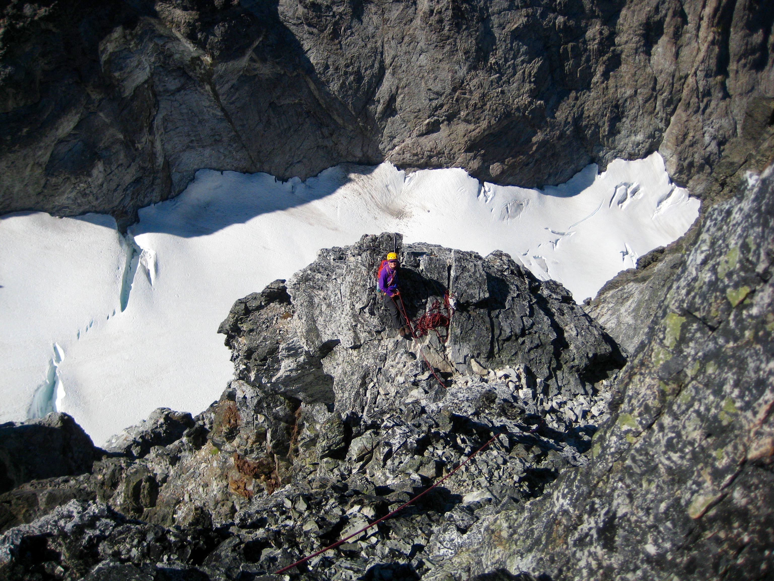 Looking down on mountain climber belaying on the third and final summit pitch on Hard Mox Peak