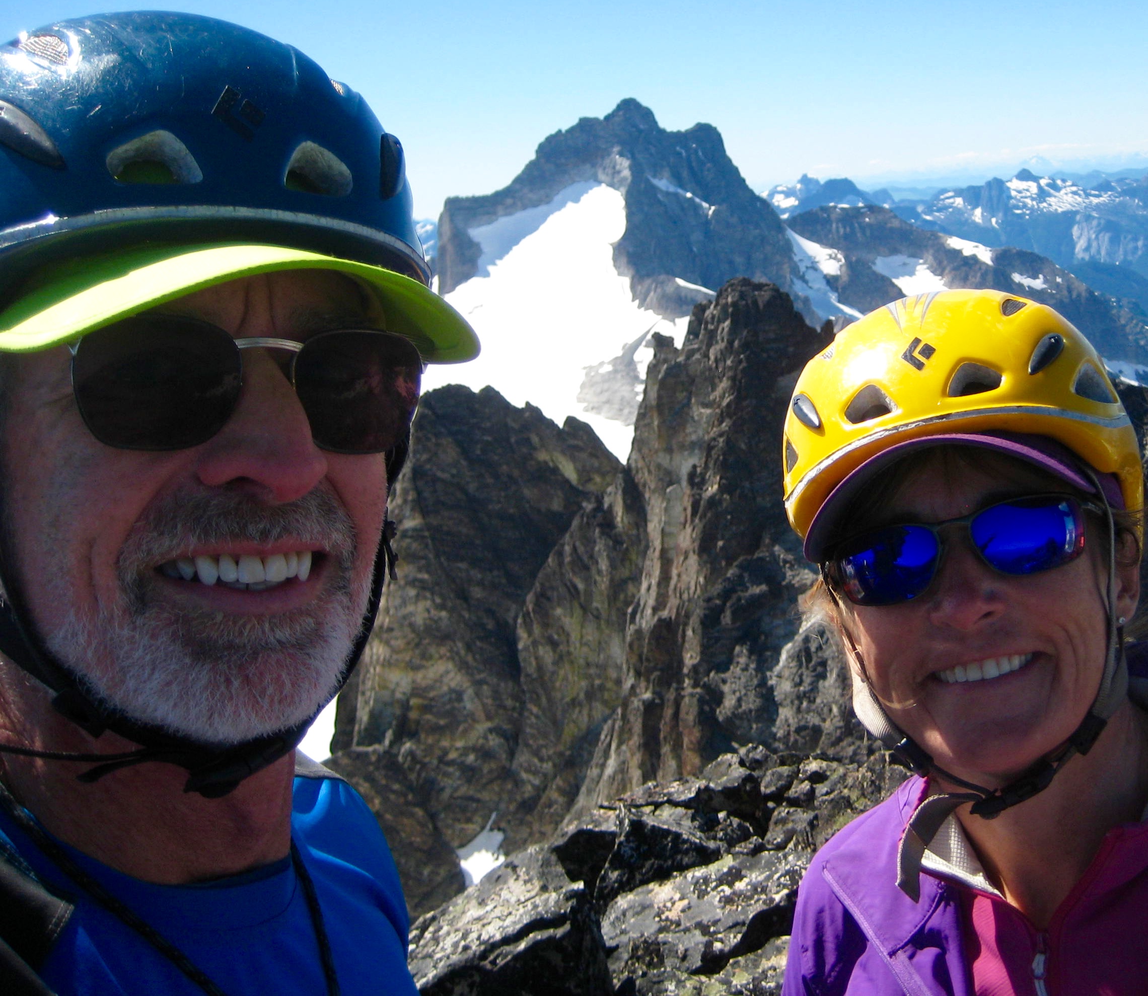selfie of mountain climbers on the summit of Hard Mox Peak in the Amiercan Chilliwack Mountains with Mt Redoubt in the background