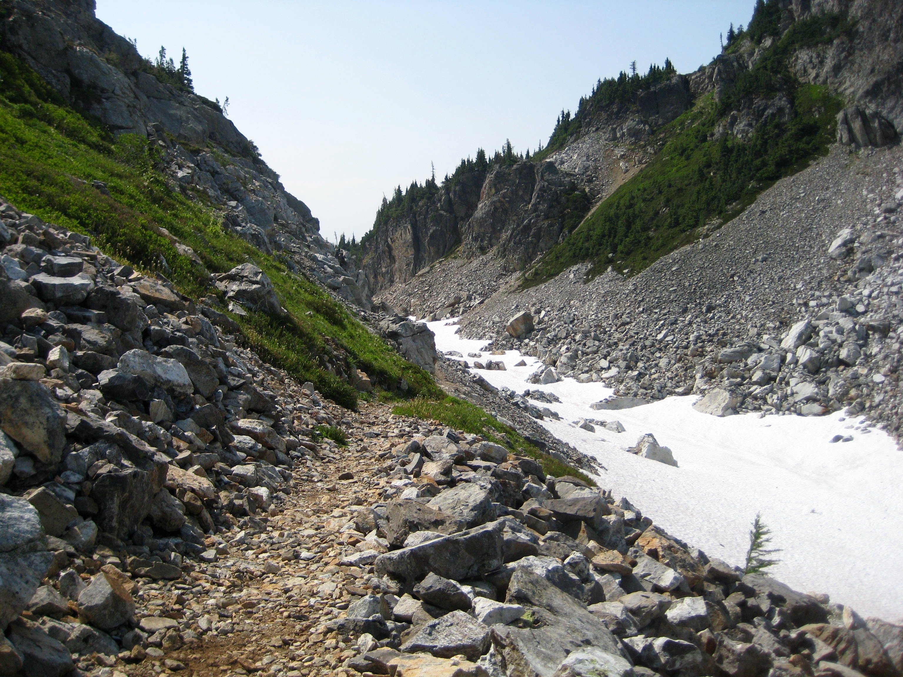 Park Creek Pass trail with linguring snow patch in scree drainage in the North Cascades enroute to Mt Logan