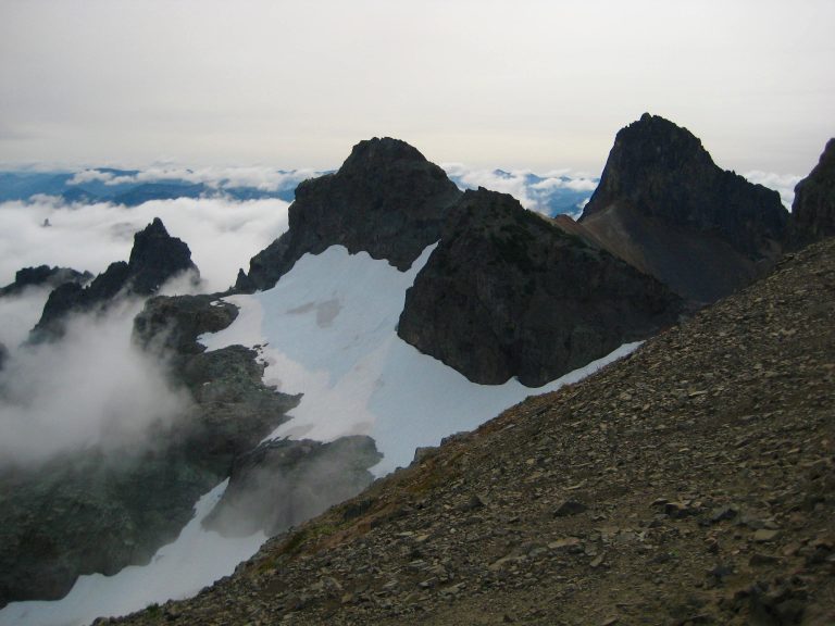 North, Middle, and Main Cowlitz Chimneys summit horns with linguring snow patchs as seen from Banshee Ridge in Mt Rainier National Park