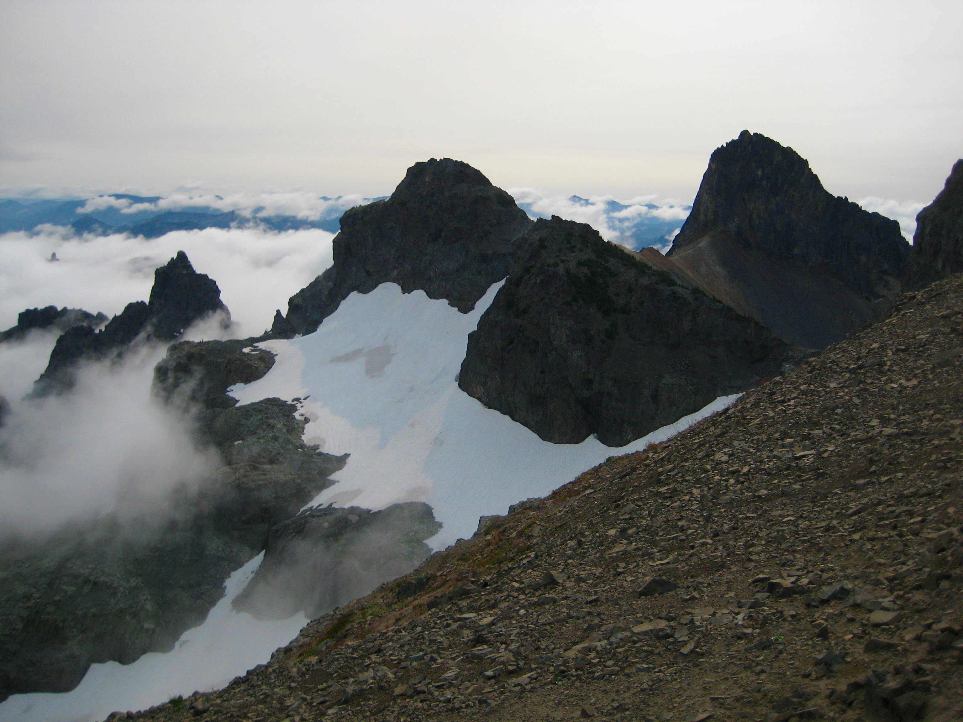 North, Middle, and Main Cowlitz Chimneys summit horns with linguring snow patchs as seen from Banshee Ridge in Mt Rainier National Park