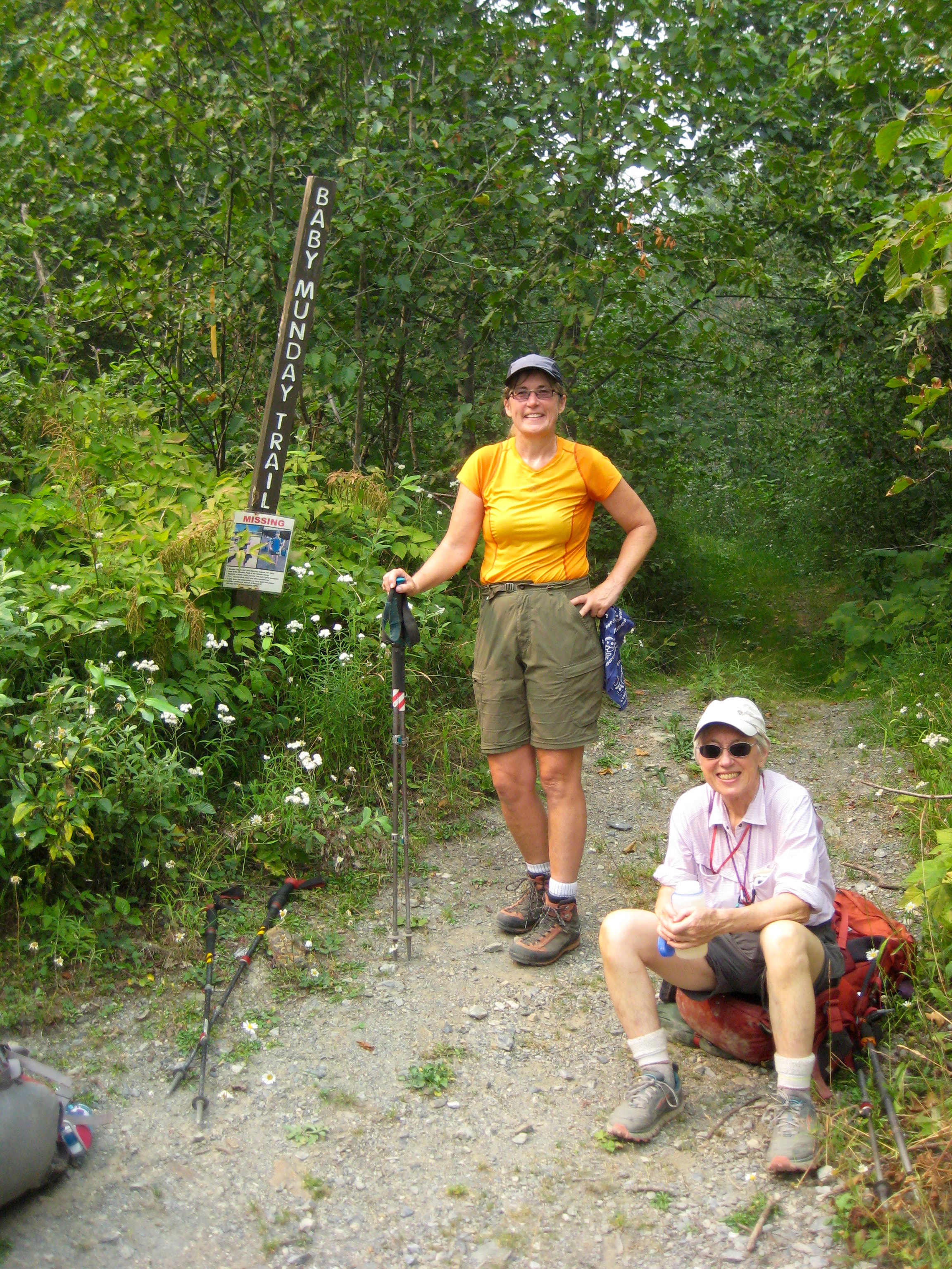 mountain climbers taking a break at the trailhead sign for Baby Munday in the Cheam Range BC Canada