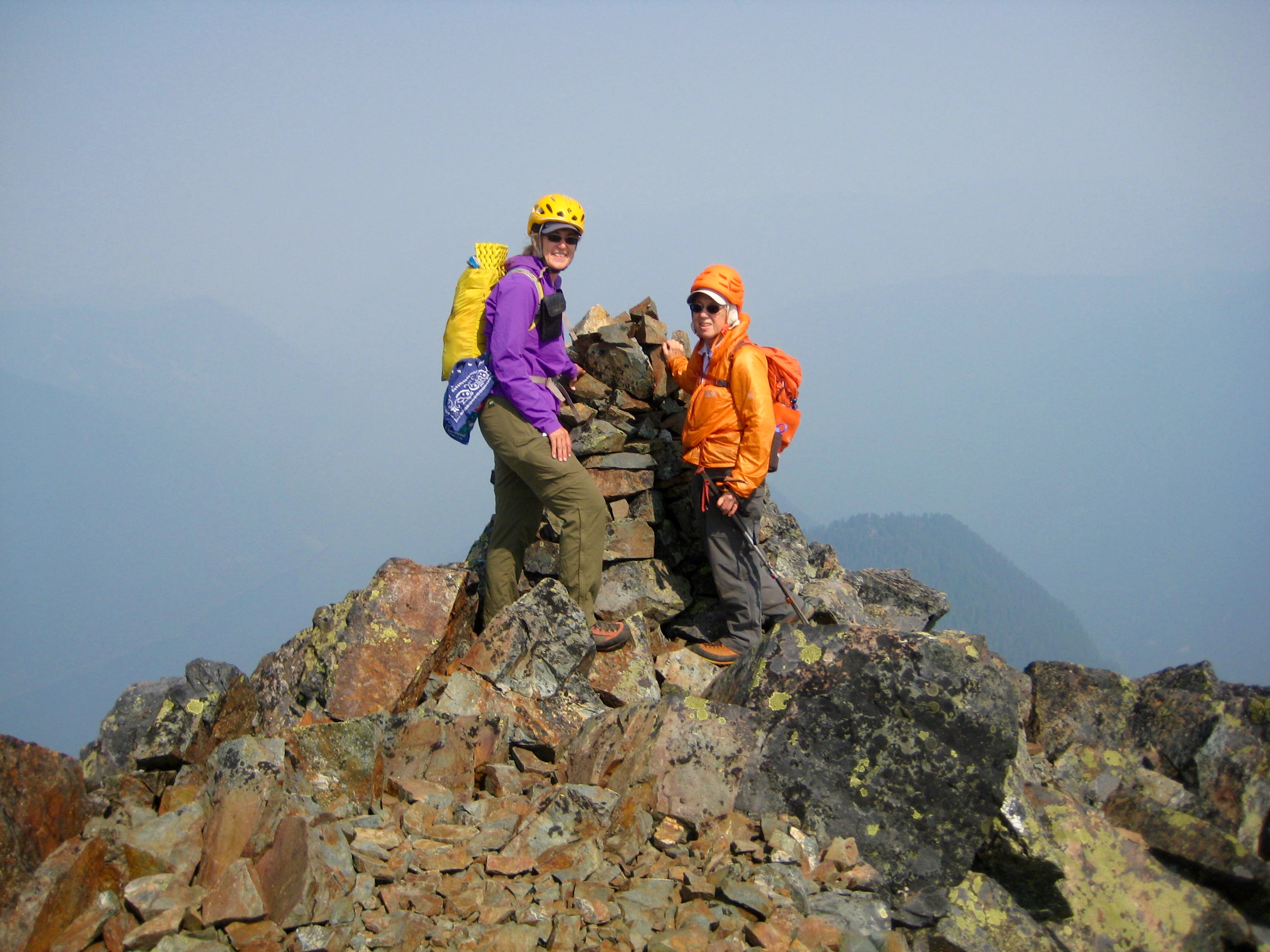 mountain climbers standing with large rock cairn on the summit of Stewart Peak in the Cheam Range
