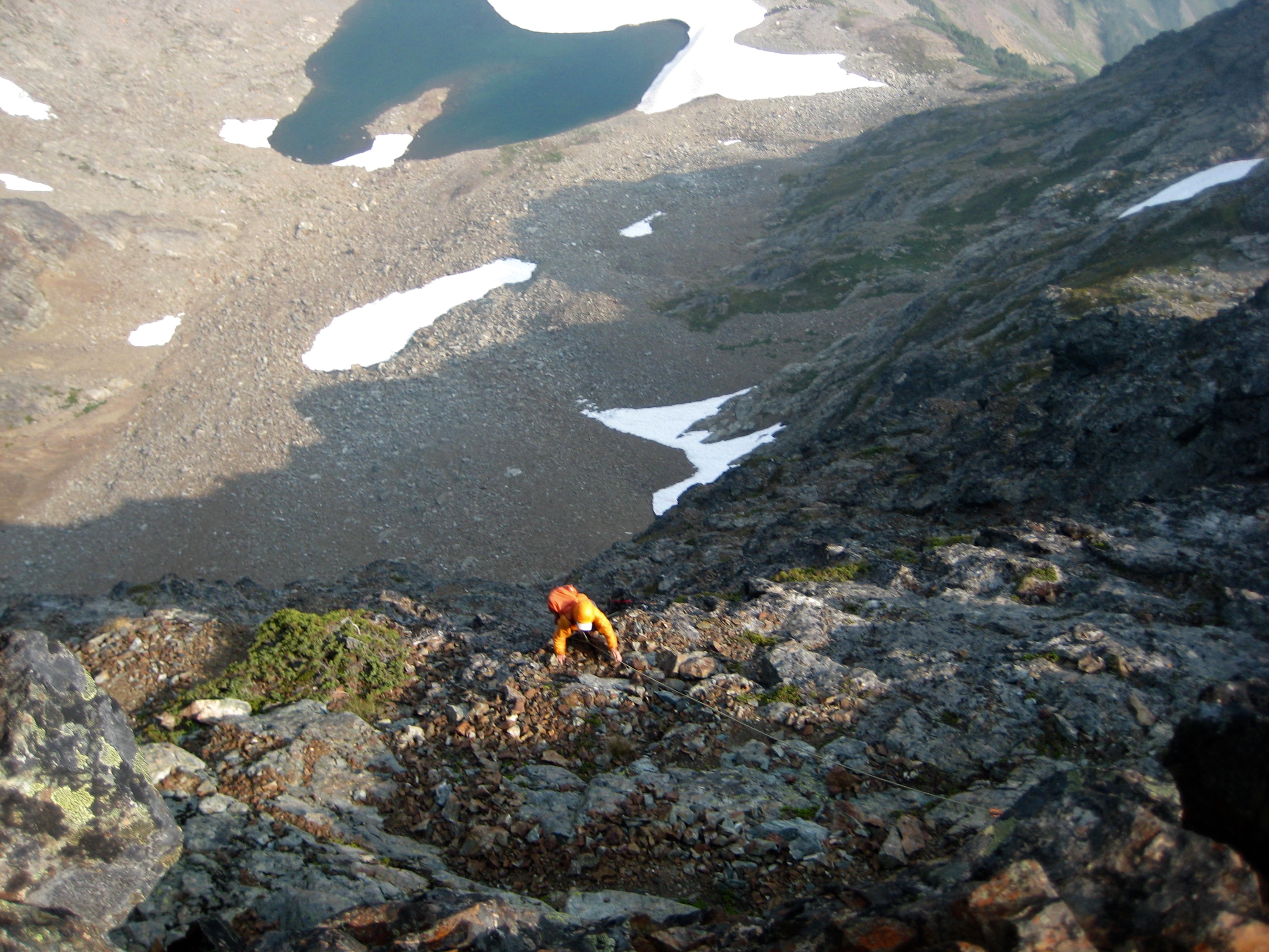 looking down on roped mountain climbers scrambling the steep, loose southeast face of Baby Munday Peak in the Cheam Range with Baby Munday Lake far below