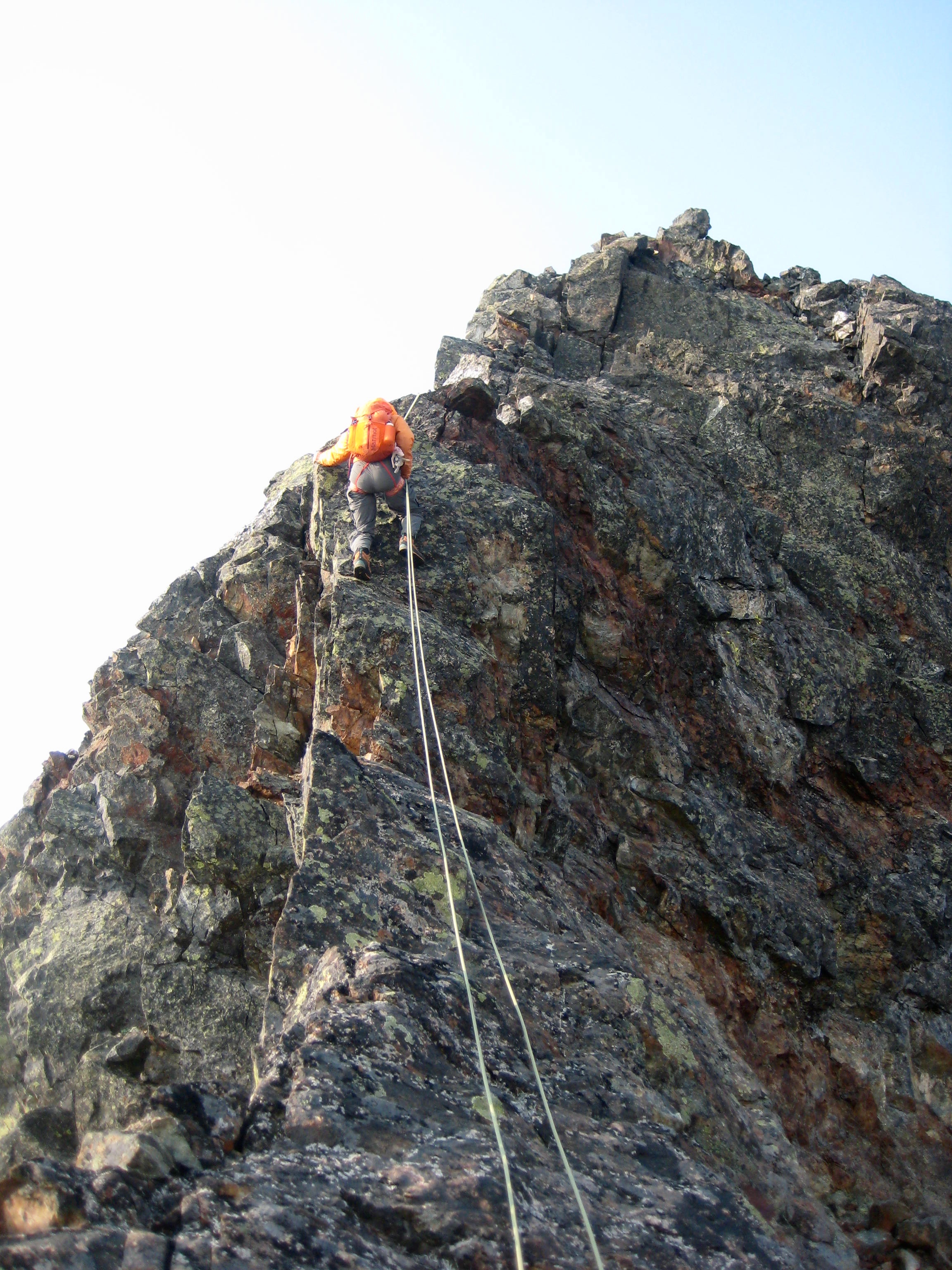 mountain climber rappelling the vertical rock step on the south ridge of Baby Munday Peak in the Cheam Ridge