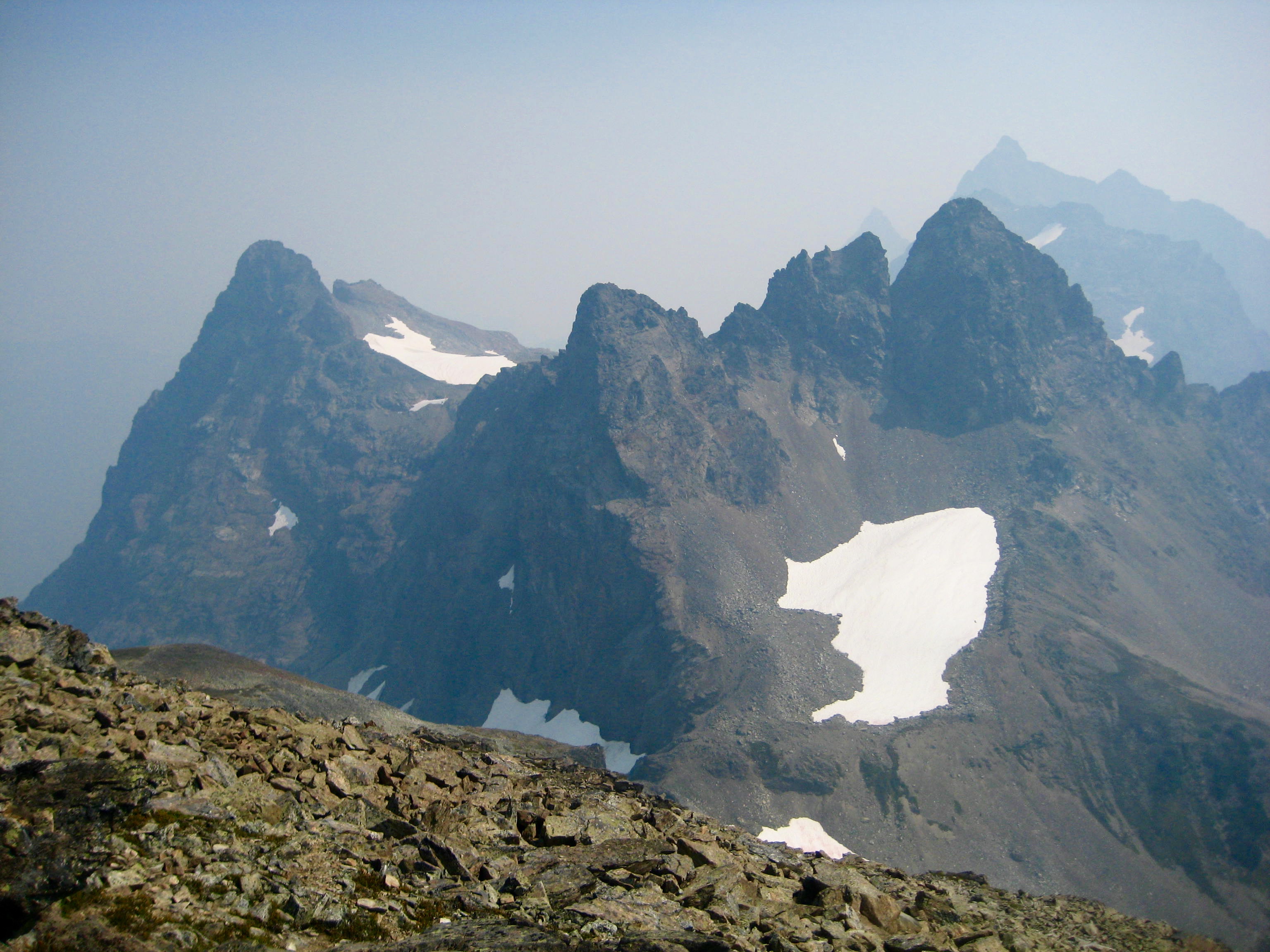 Stewart Peak and Baby Munday Peak with snow patches and smokey air as seen from Knight Peak in the Cheam Range