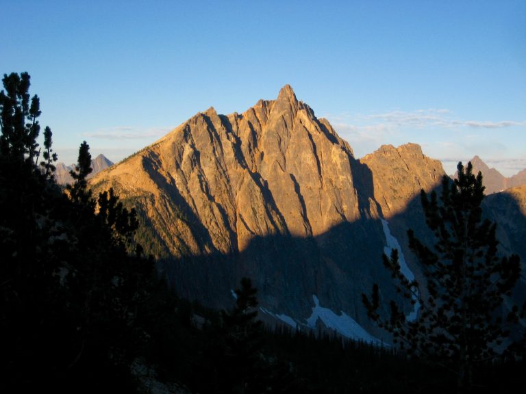 Alpenglow warms the steep north face of Mt Hardy seen from Snowy Lakes in the Upper Methow Mountains