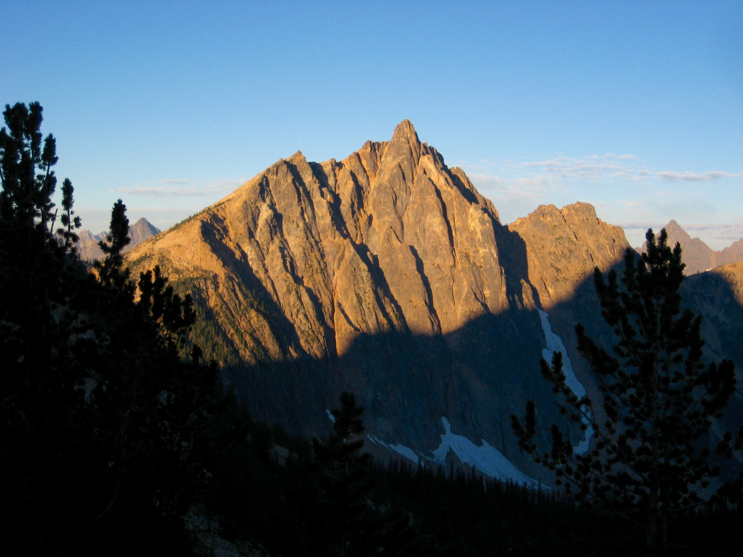 Alpenglow warms the steep north face of Mt Hardy seen from Snowy Lakes in the Upper Methow Mountains