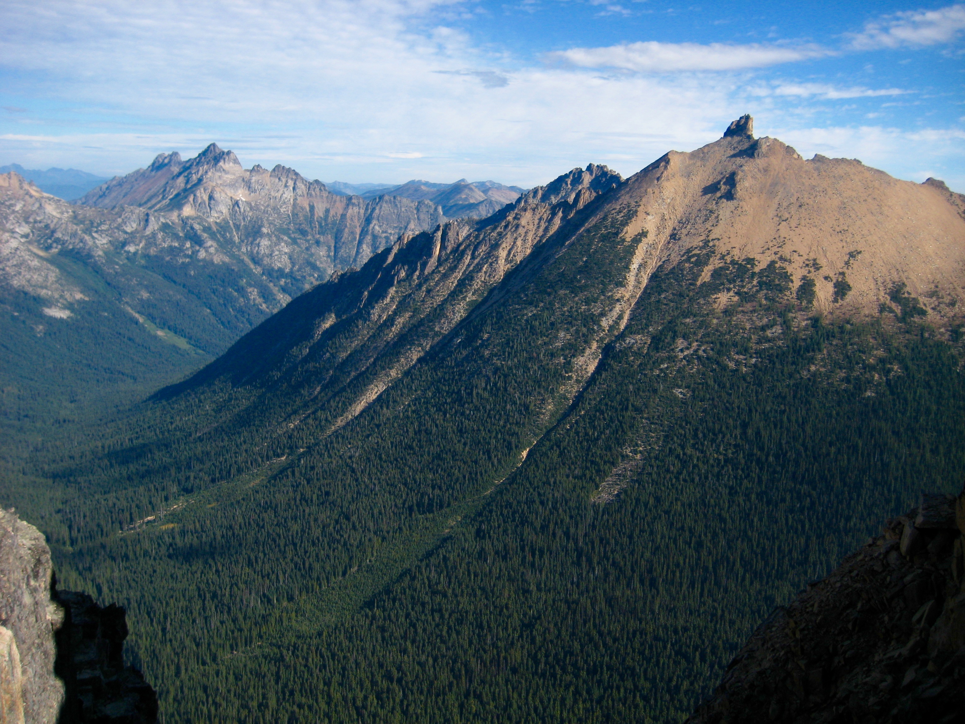 Mt Ballard, Azurite Peak, and Golden Horn Peak with wafting clouds as seen from the summit of Mt Hardy in the Upper Methow Mountains