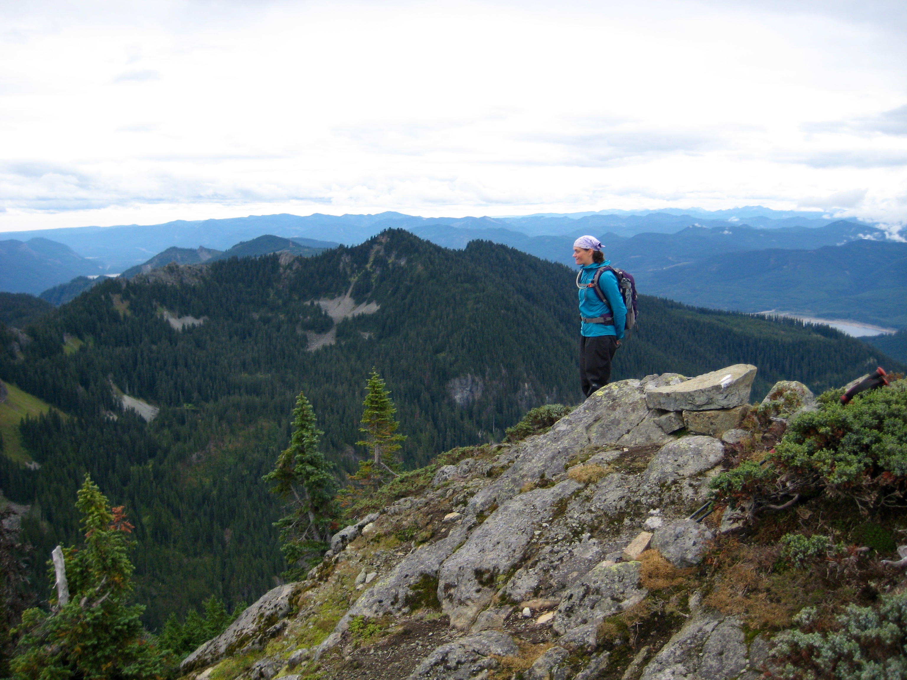 A mountain climber stands on the summit of Dungeon Peak overlooking Lake Keechelus