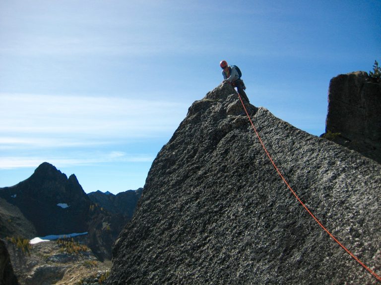 Rock Climber on Concord Tower at the Top of the Shark Fin with summit block off to the right