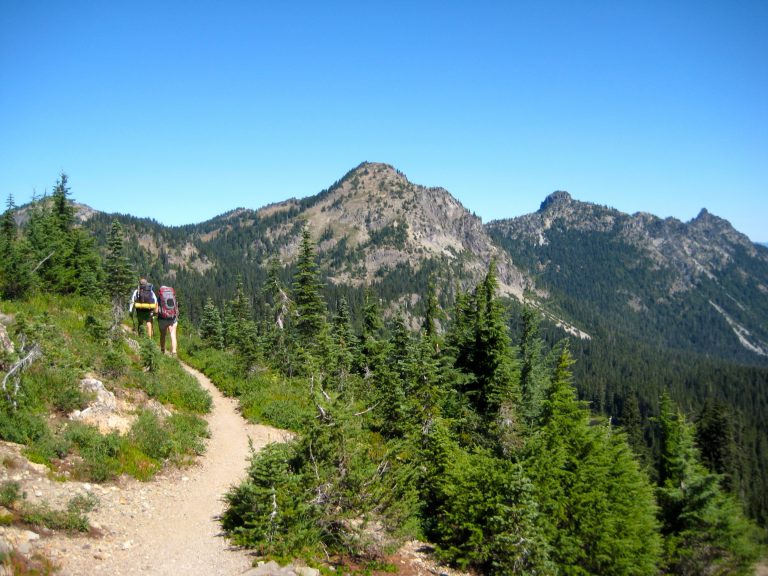 Two hikers walk along the Pacific Crest Trail near Mt Rainier