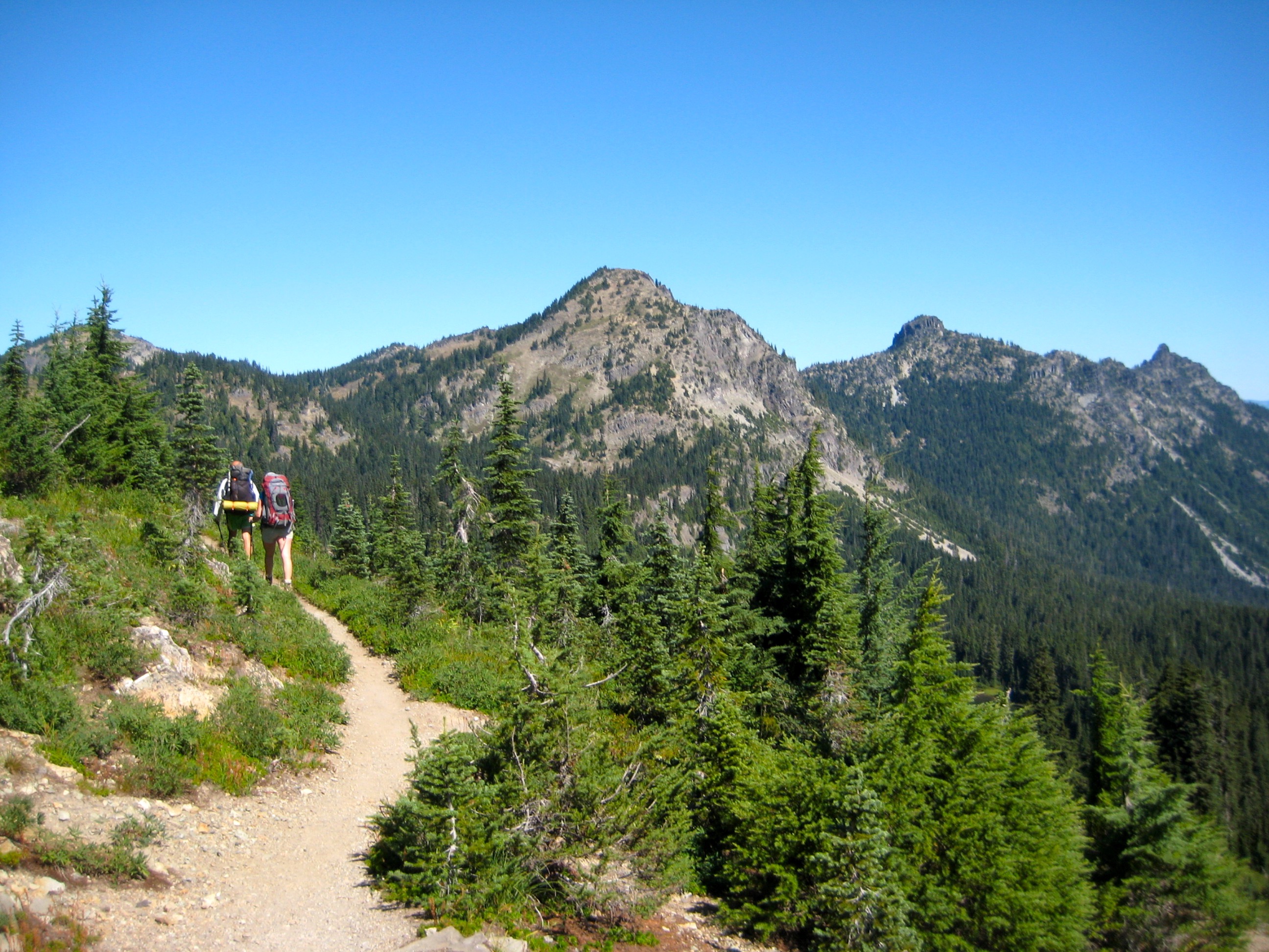 Two hikers walk along the Pacific Crest Trail near Mt Rainier