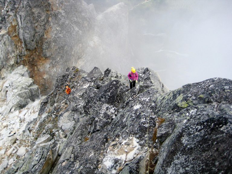 Mountain climbers ascend a steep granite ridge crest on Bear Mountain in the American Chilliwack Mountains