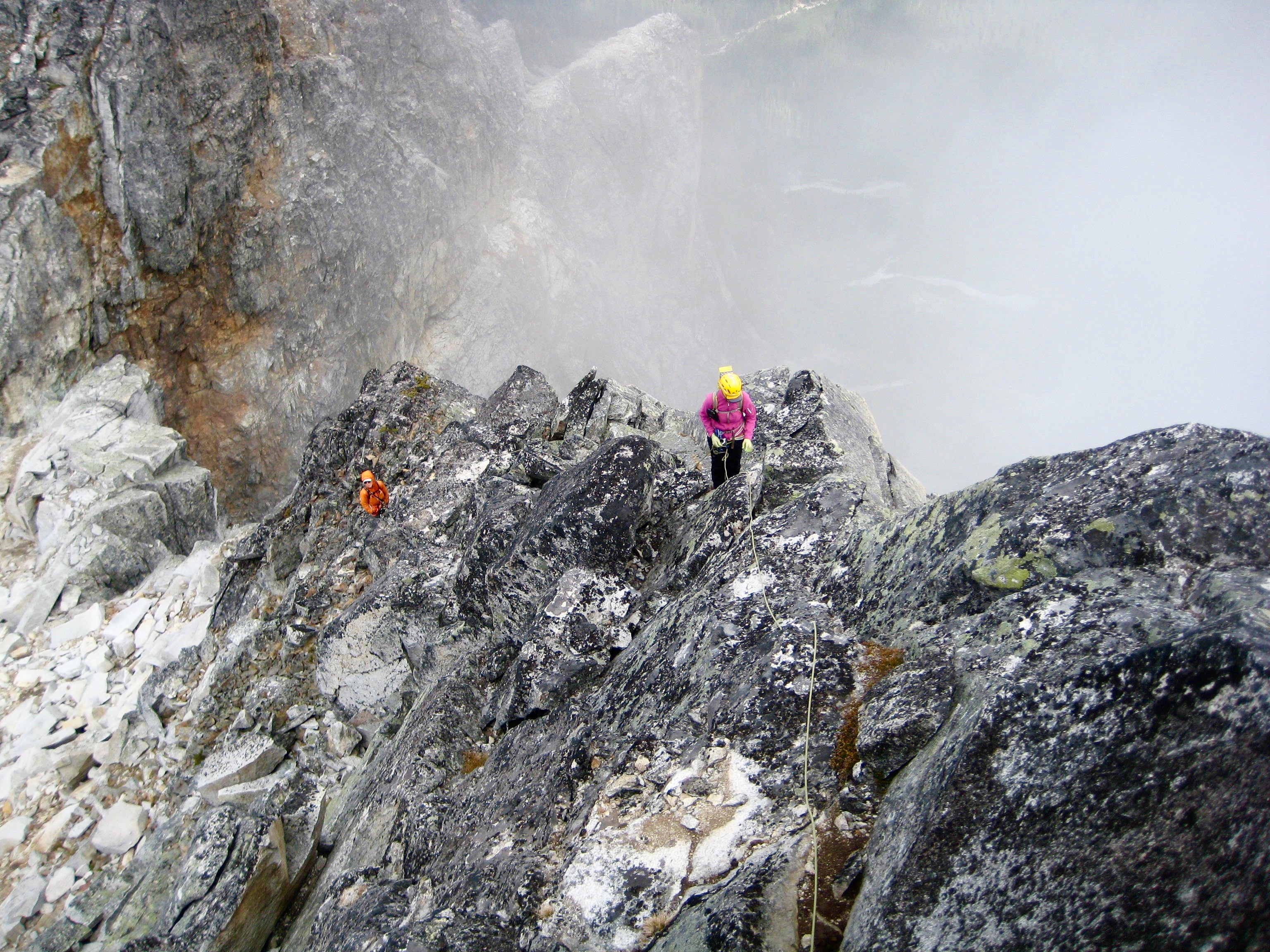 Mountain climbers ascend a steep granite ridge crest on Bear Mountain in the American Chilliwack Mountains