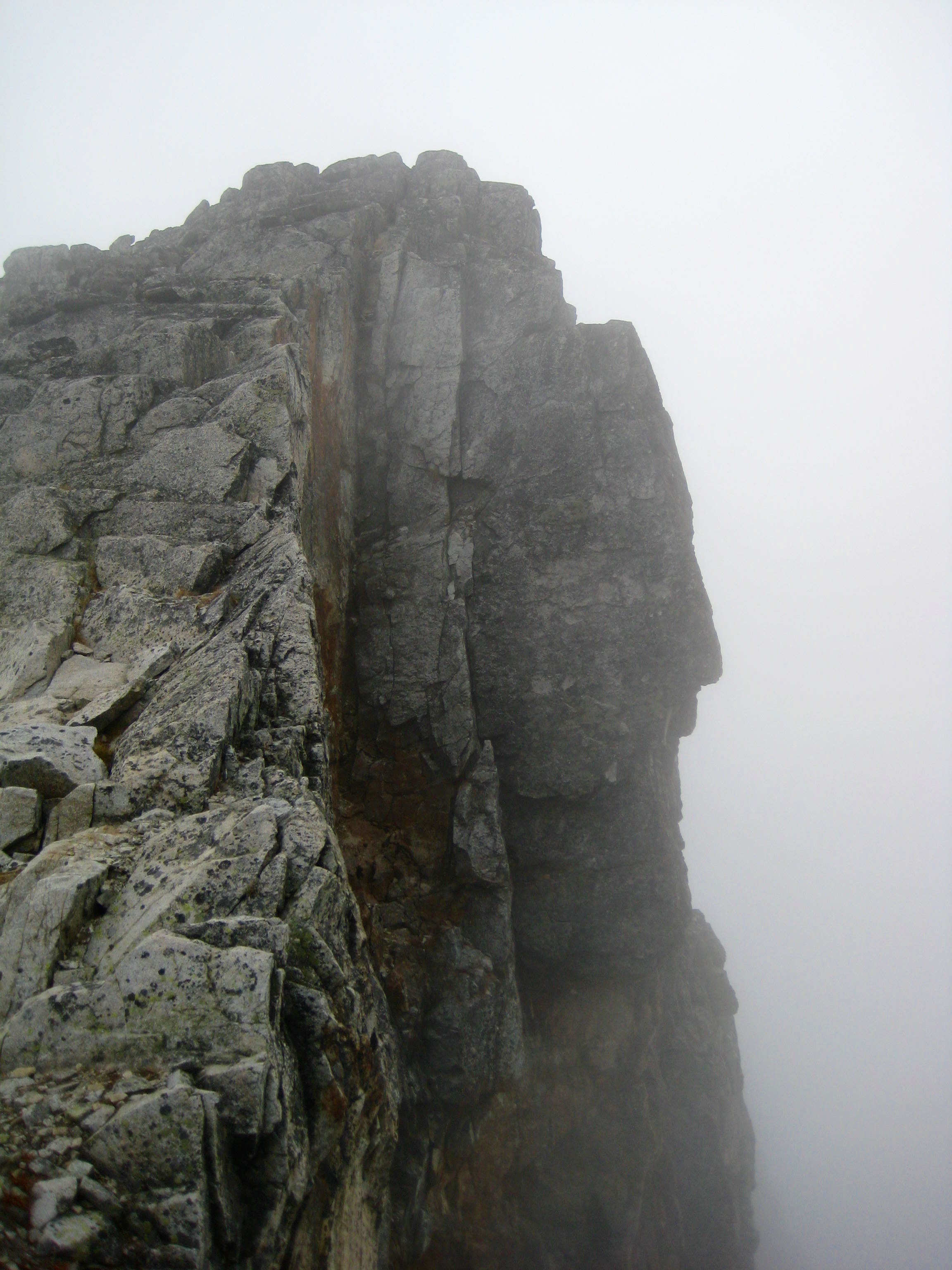 shear rock cliff on the East Face of Bear Mountain in North Cascades National Park engulfed in fog layer