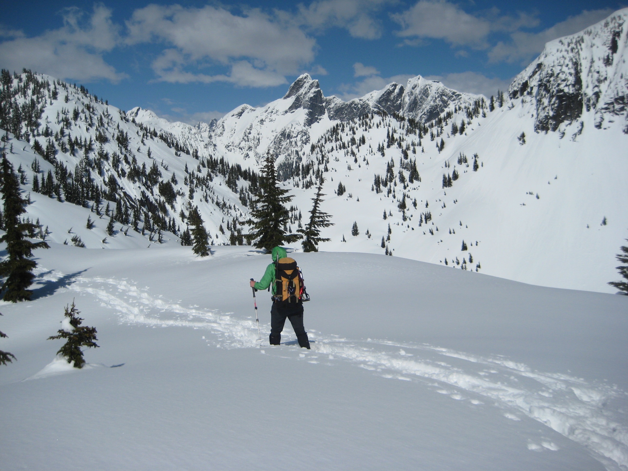 A snowshoer walks along the crest of a snowy ridge en route to Salvation Peak