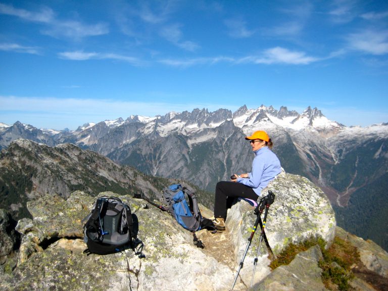 A mountain climber sits on Trappers Peak overlooking the rugged Picket Range
