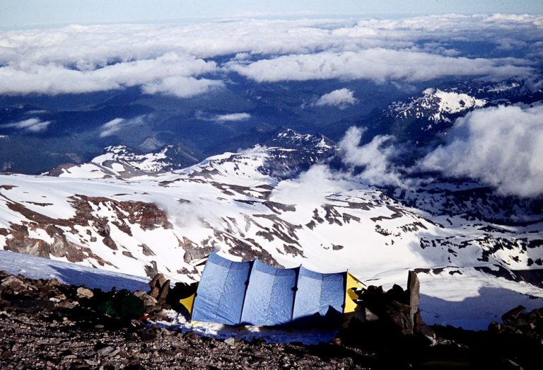 Mountain climbers relax at their tent pitched high on the flank of Mt. Rainier