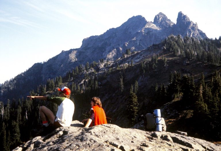Climbers taking a break on Spectacle Point with Three Queens Mountain in the background