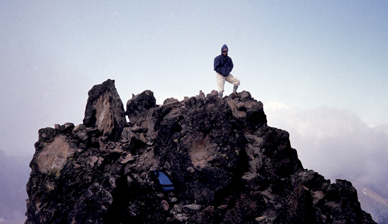 A mountain climber stands on the summit of Mt Curtis Gilbert in the Goat Rocks Wilderness