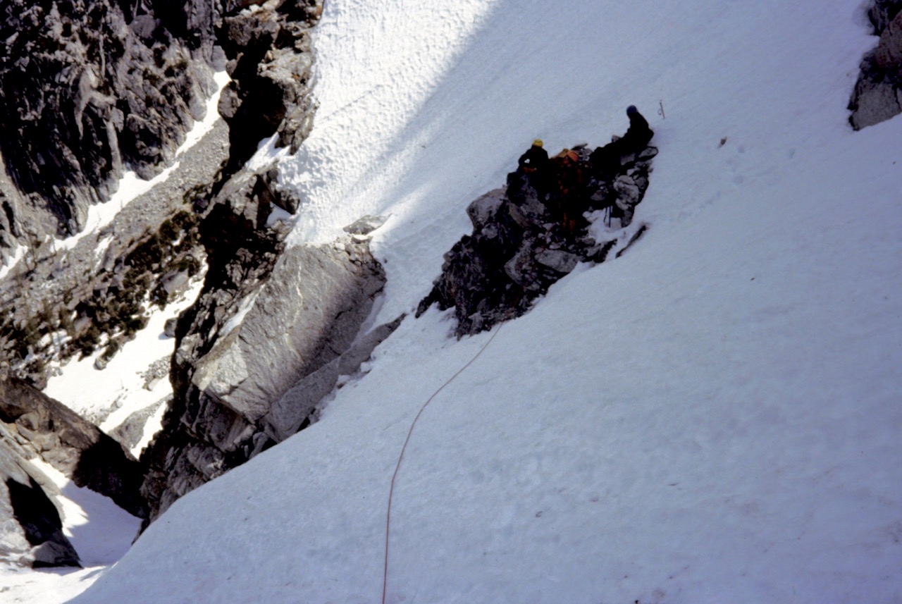 Three climbers at the belay station in the snow couloir heading up Dragontail Peak