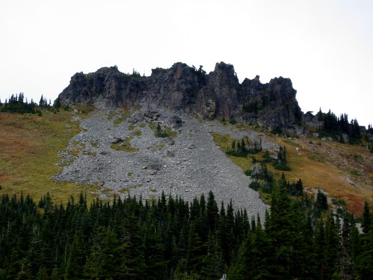 Grass and rock slopes lead up to the broad jagged ridge of Hessong Rock